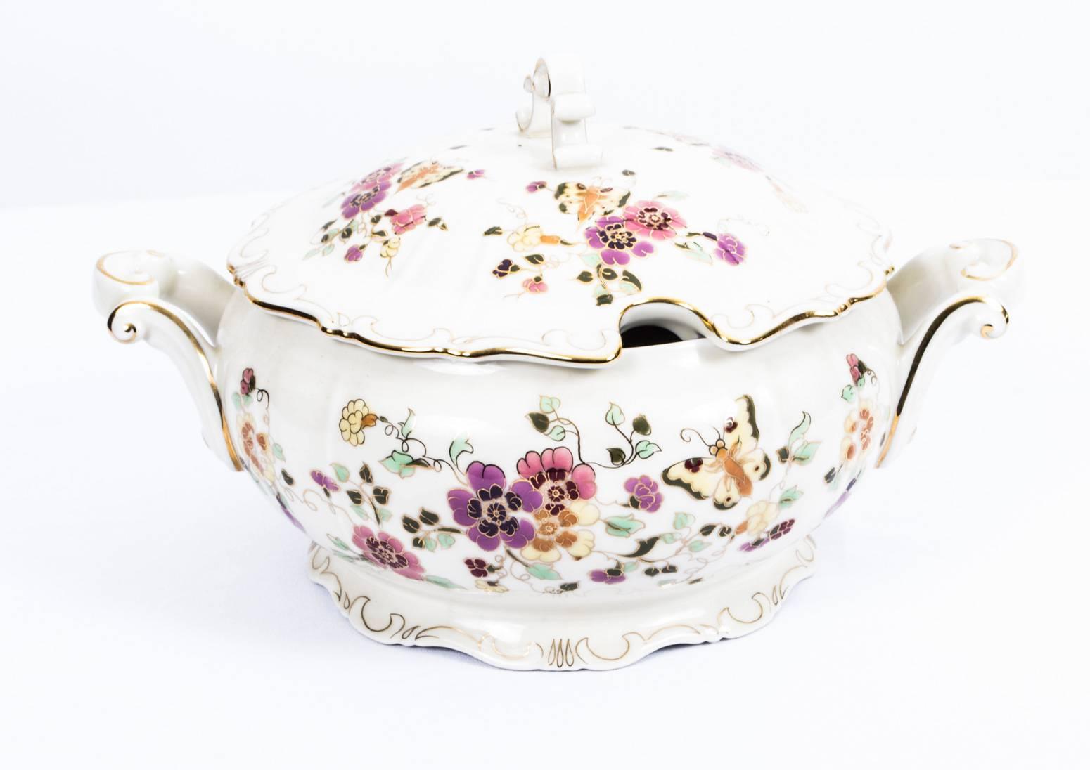 An extensive beautiful Zsolnay Porcelain dinner, tea and coffee service for eight, hand-painted with hellebores and butterflies, picked out in gilt throughout on a cream ground, circa 1930 in date.

Each piece is stamped 'Zsolnay HUNGARY