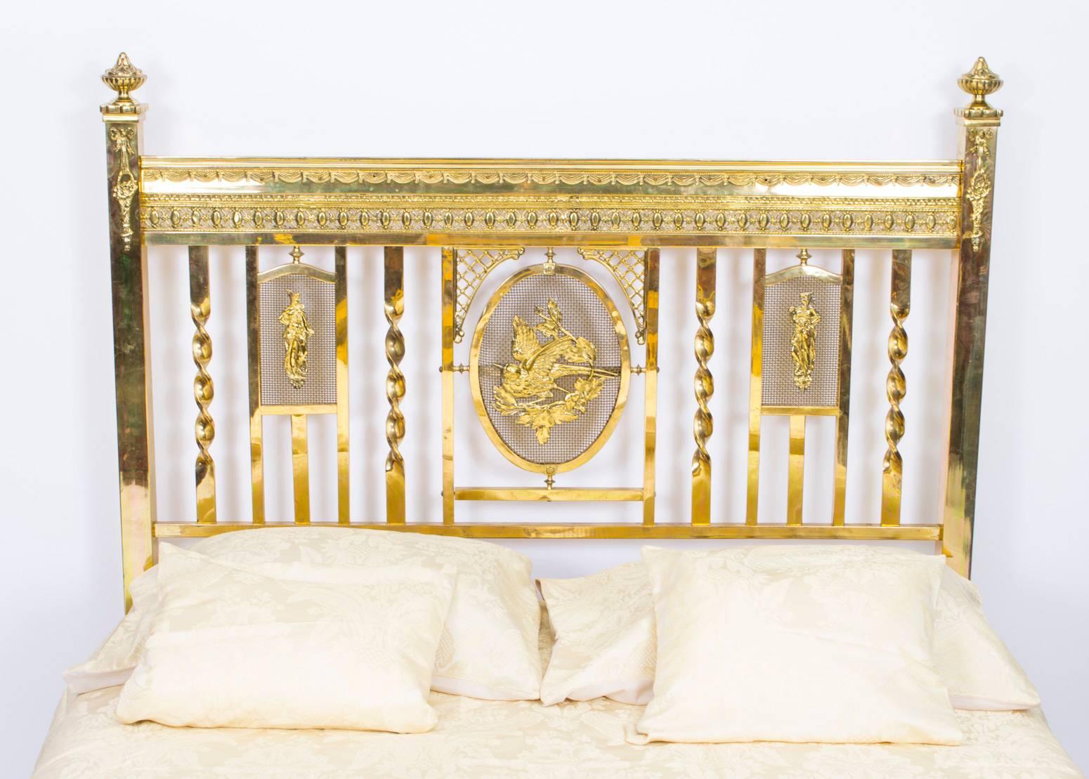 This is a lovely antique Edwardian polished brass double bedstead, circa 1900 in date. 

It has a delightful central gilt mesh panel of a bird with figural motifs on either side, square supports decorated with baskets and ribbons, corner finials