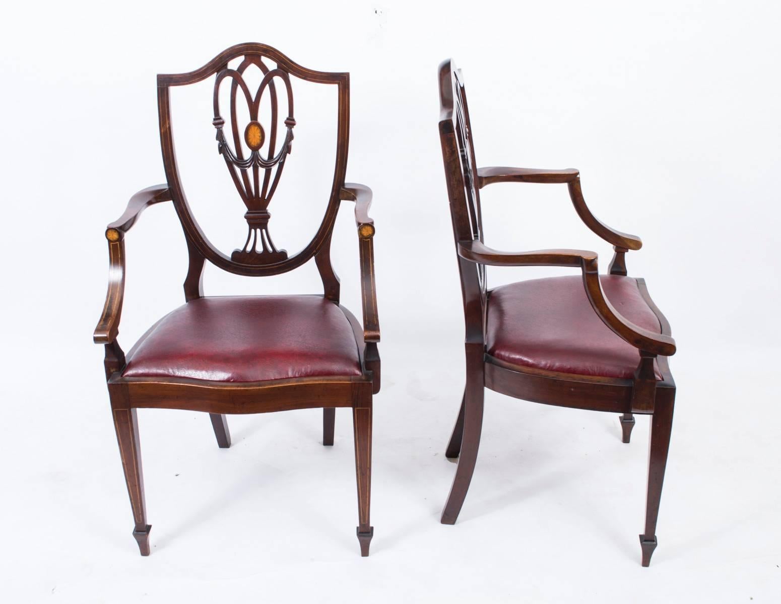 This is a fantastic antique English set of eight mahogany and boxwood inlaid Hepplewhite style dining chairs, circa 1900 in date.

Comprising six singles and two carvers, with pierced back supports centred by inlaid shell patera, with red