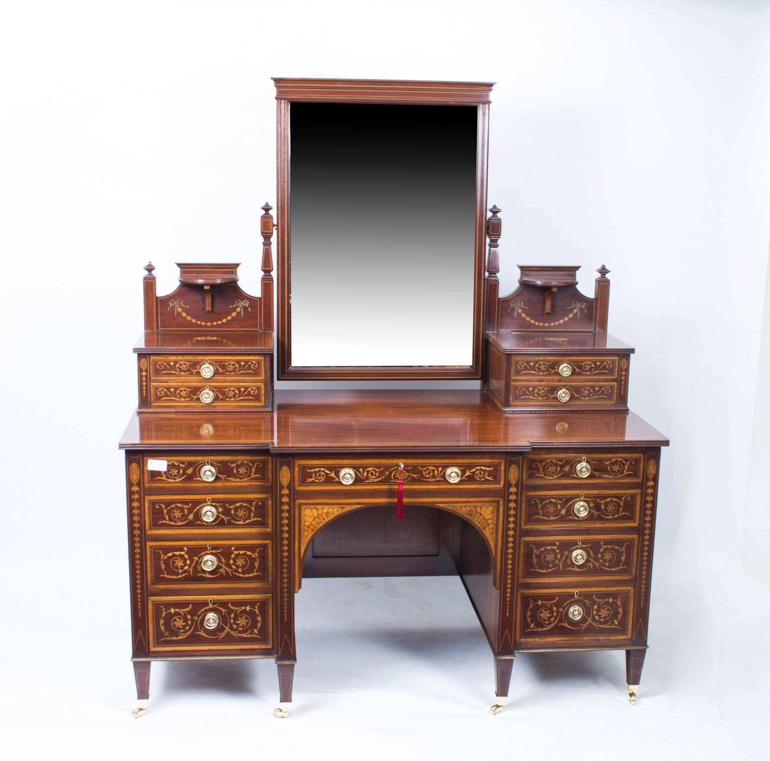 This is a spectacular antique late Victorian inlaid flame mahogany bedroom suite comprising a wardrobe and dressing table, bearing the enamel plaque of the renowned Victorian retailer and cabinet maker Maple & Co, circa 1880 in date.

The wardrobe