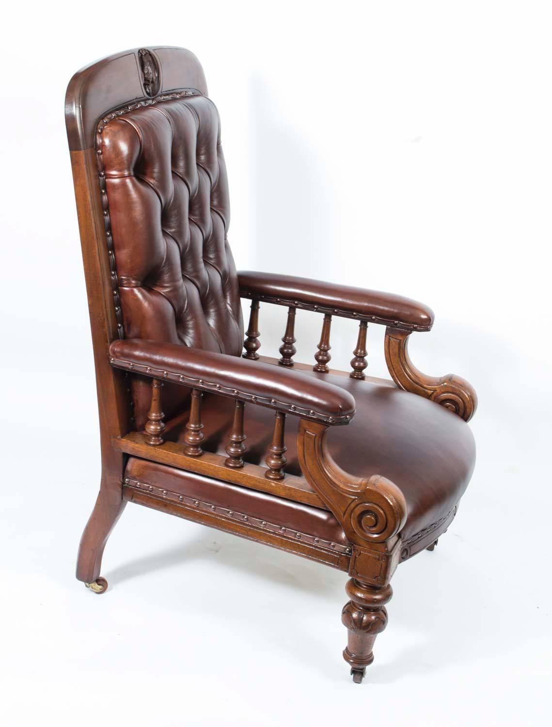 This is a handsome pair of antique Victorian mahogany and leather club armchairs, circa 1880 in date.

This lovely pair was made from masterly crafted hand-carved solid mahogany with an interesting hand-carved crest of a bird on top of each.

They