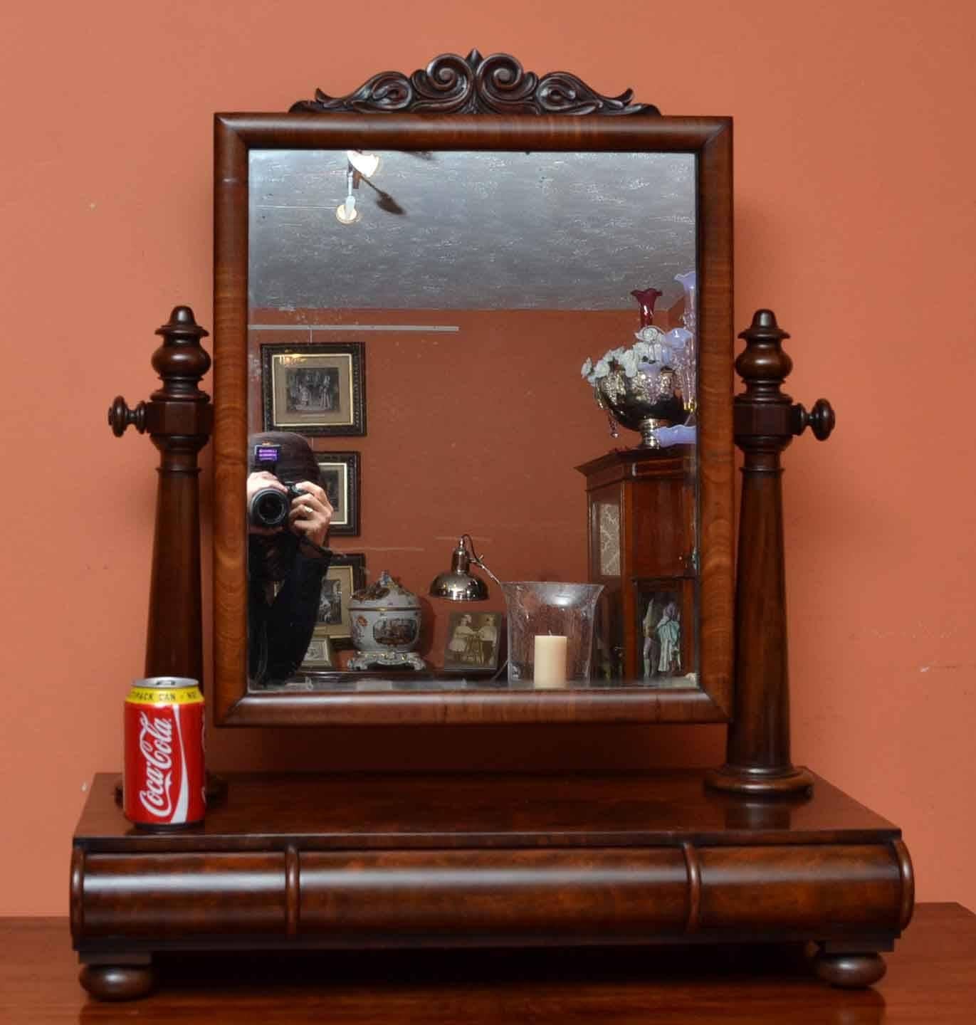 This is an antique English dressing table swivel mirror, circa 1840 in date. 

It is made from flame mahogany and has a useful drawer underneath for storing your brushes and combs. The mirror has hand carved floral decorations to the pediment.