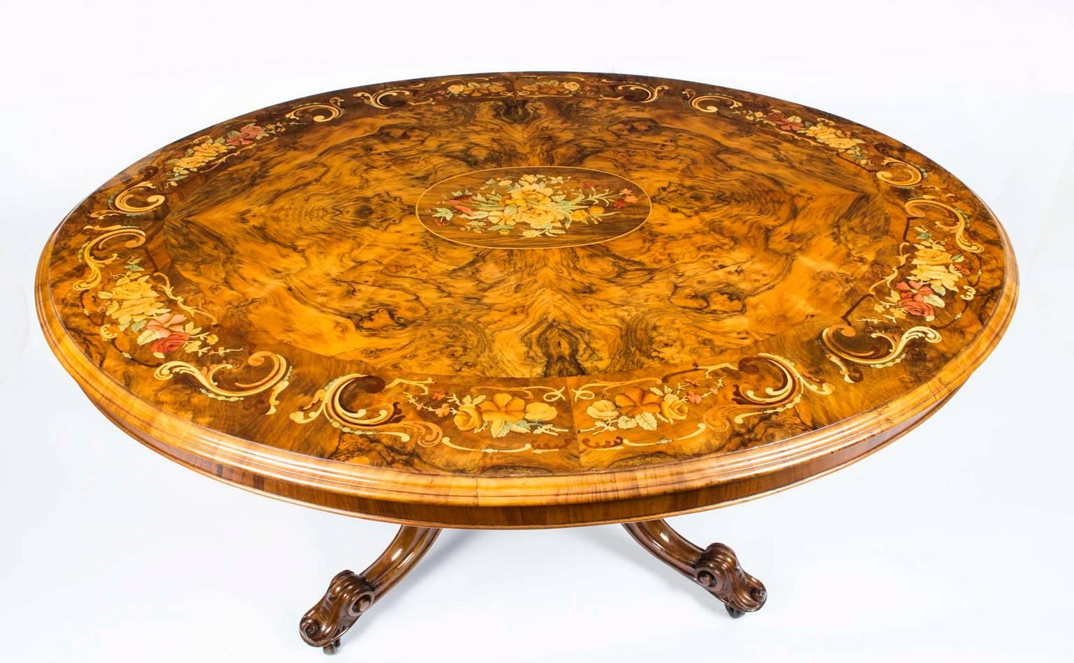 This is a superb Victorian burr walnut and marquetry loo table, circa 1860 in date.

The tabletop is oval in shape and features wonderful butterflied burr walnut with superb marquetry floral inlaid decoration. The base is hand-carved from solid
