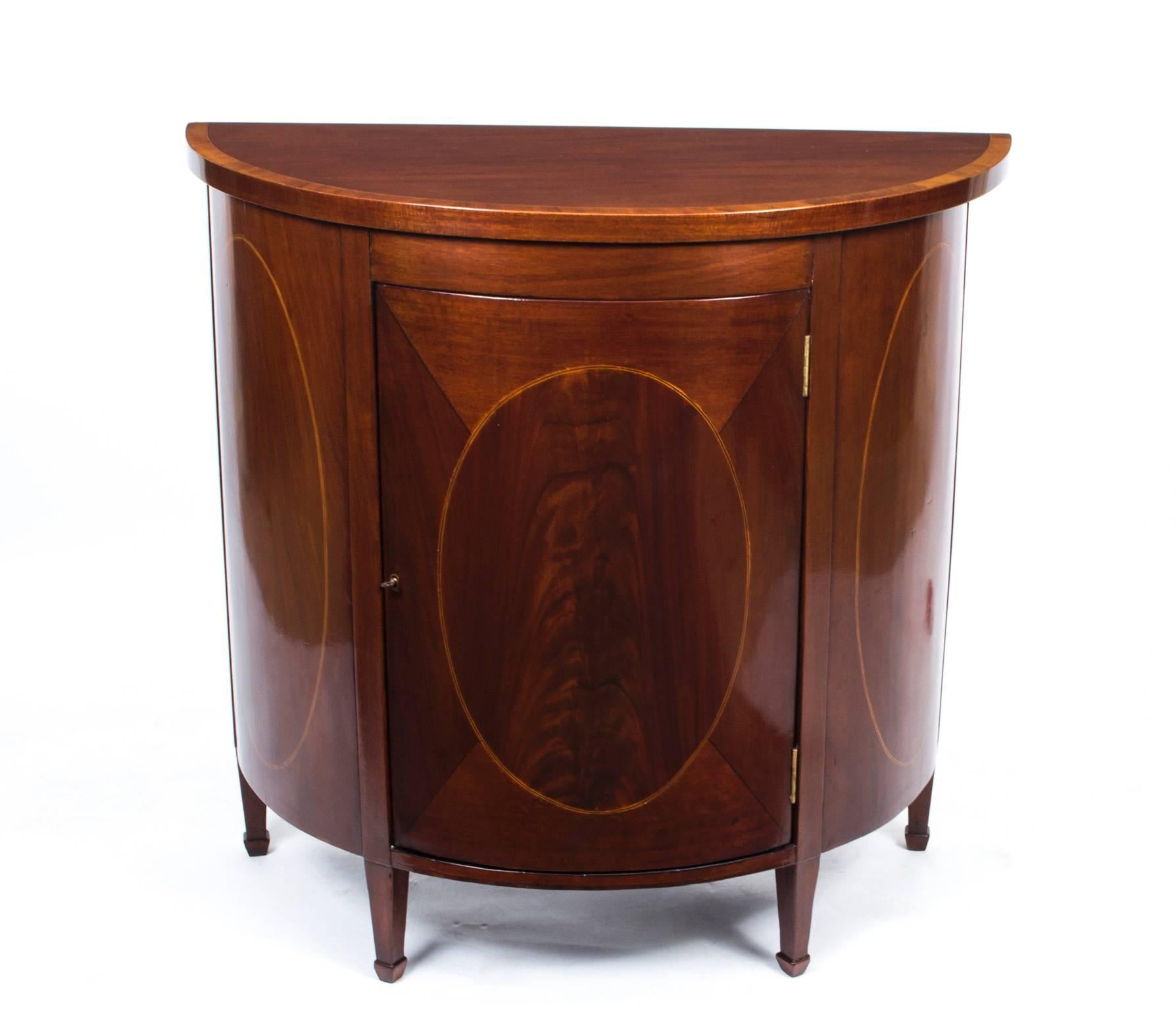 This is a lovely antique Victorian half-moon commode in beautiful Sheraton style. There is no mistaking the unique quality and design and it will soon become the centerpiece of your furniture collection. This lovely commode will instantly enhance