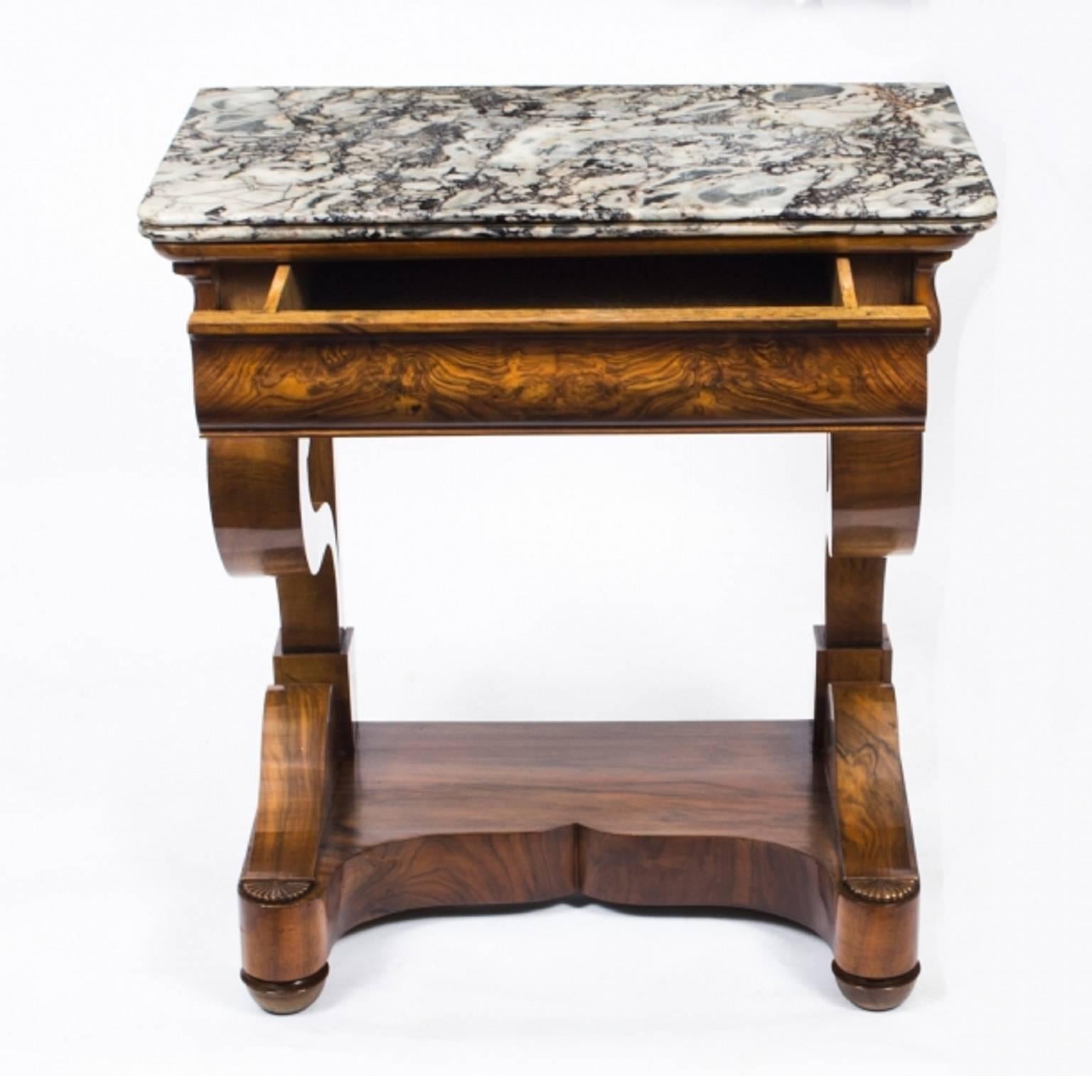 This is a very elegant and petite antique French Charles X period finely figured walnut console table, circa 1830 in date.

This beautiful console table retains its original Gris St Anne marble top has a useful frieze drawer and stands on