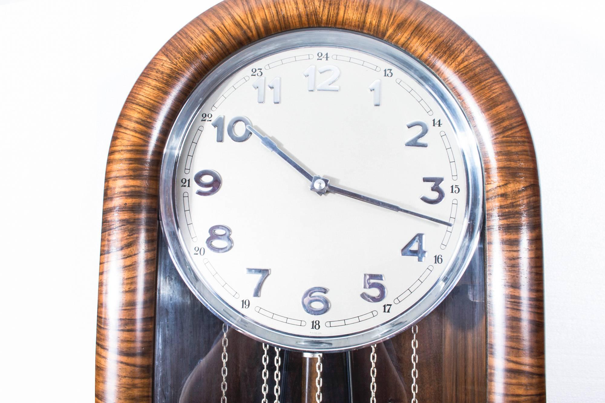An elegant English Art Deco burr walnut, Westminster chiming, longcase clock, circa 1935 in date.

The clock features a hinged glazed door on a boxed frame and a burnished silvered dial with chrome numerals.

It has three cylindrical chrome