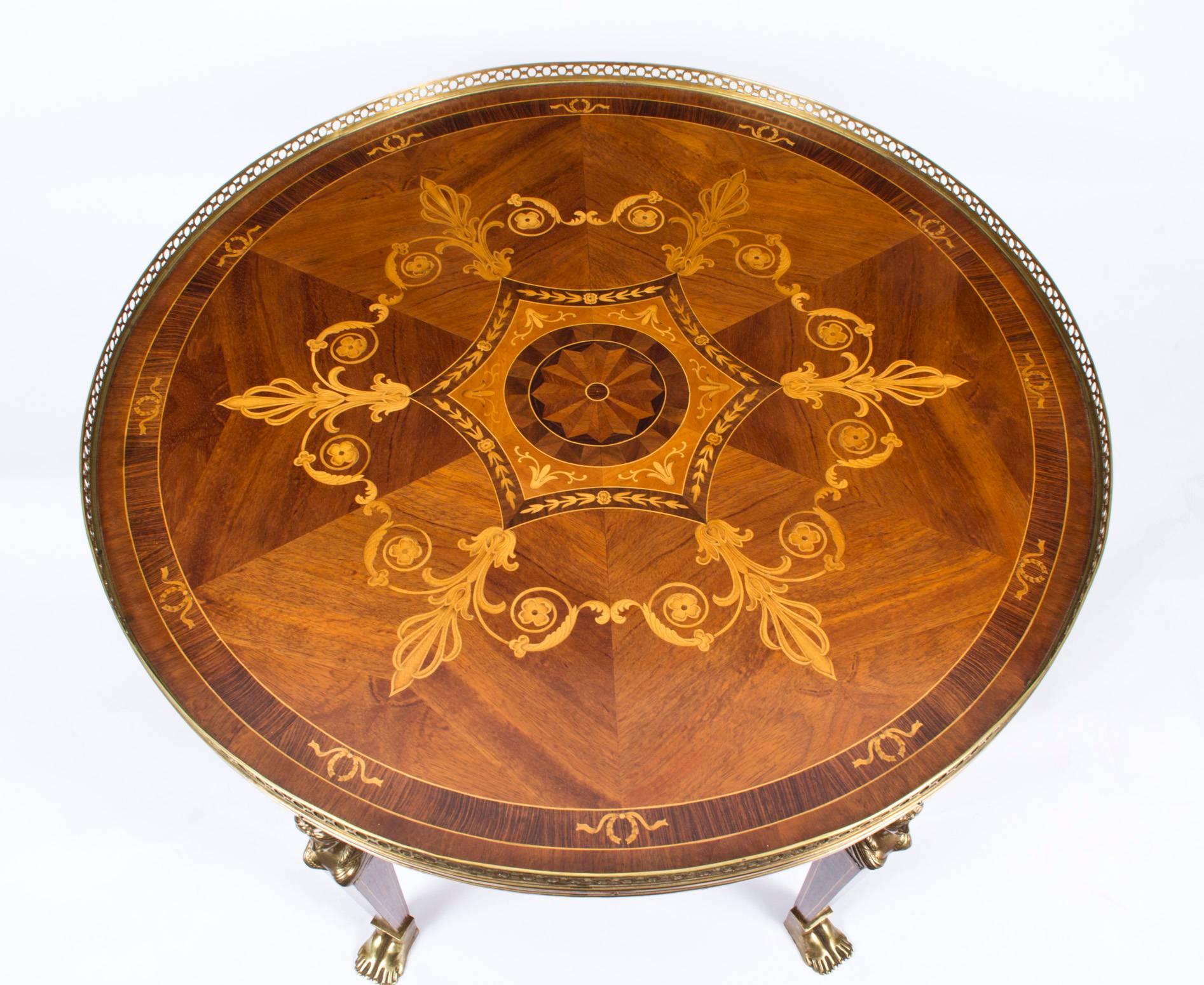 This is a striking vintage mahogany and inlaid marquetry coffee table in the elegant Empire style with fabulous decorative ormolu mounts and pierced brass gallery, circa 1970 in date.

Bought from a beautiful country house in Wales, the owners had