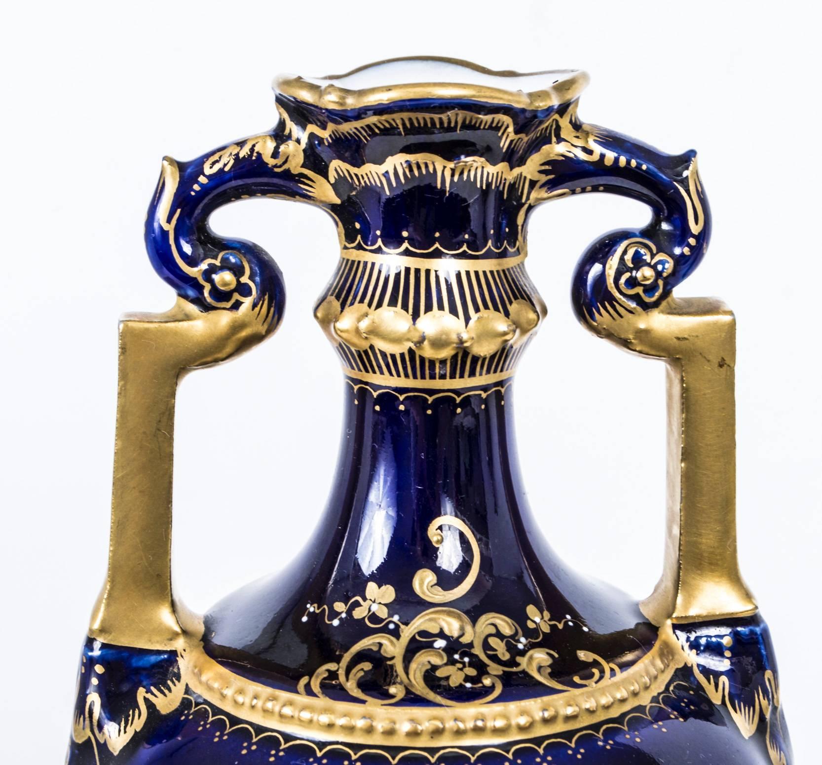 This is a wonderful pair of antique Vienna porcelain royal blue two handled classical urns on plinths.

Each with hand-painted figural panels representing Venus and cupid and bearing the blue "beehive" mark to the undersides.

This