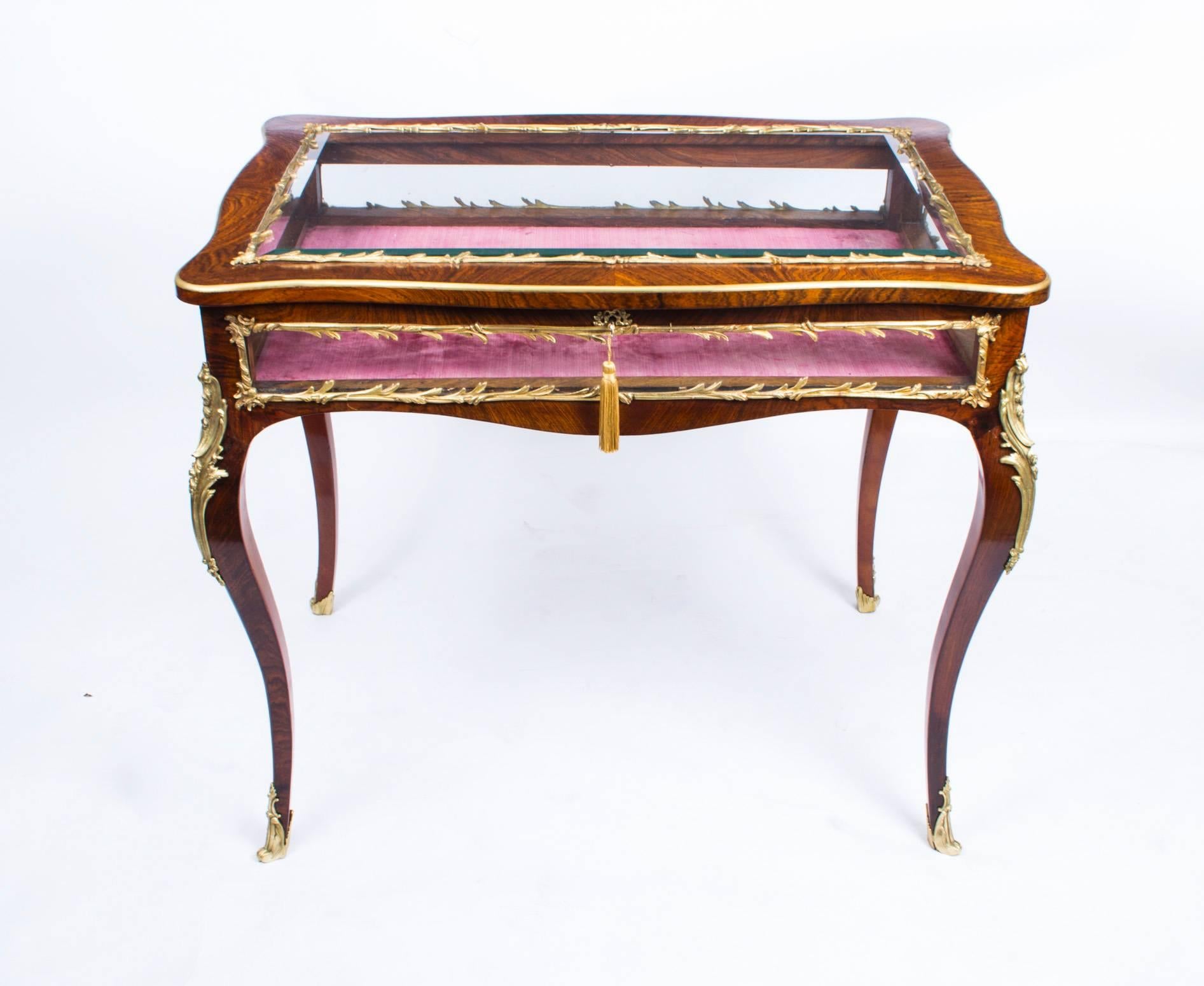 This is a beautiful antique French rosewood and ormolu mounted bijouterie display table in the Louis XV style, circa 1880 in date.

The display table features a bevelled glass top and glass sides, it has it's original pink velvet lining.

The