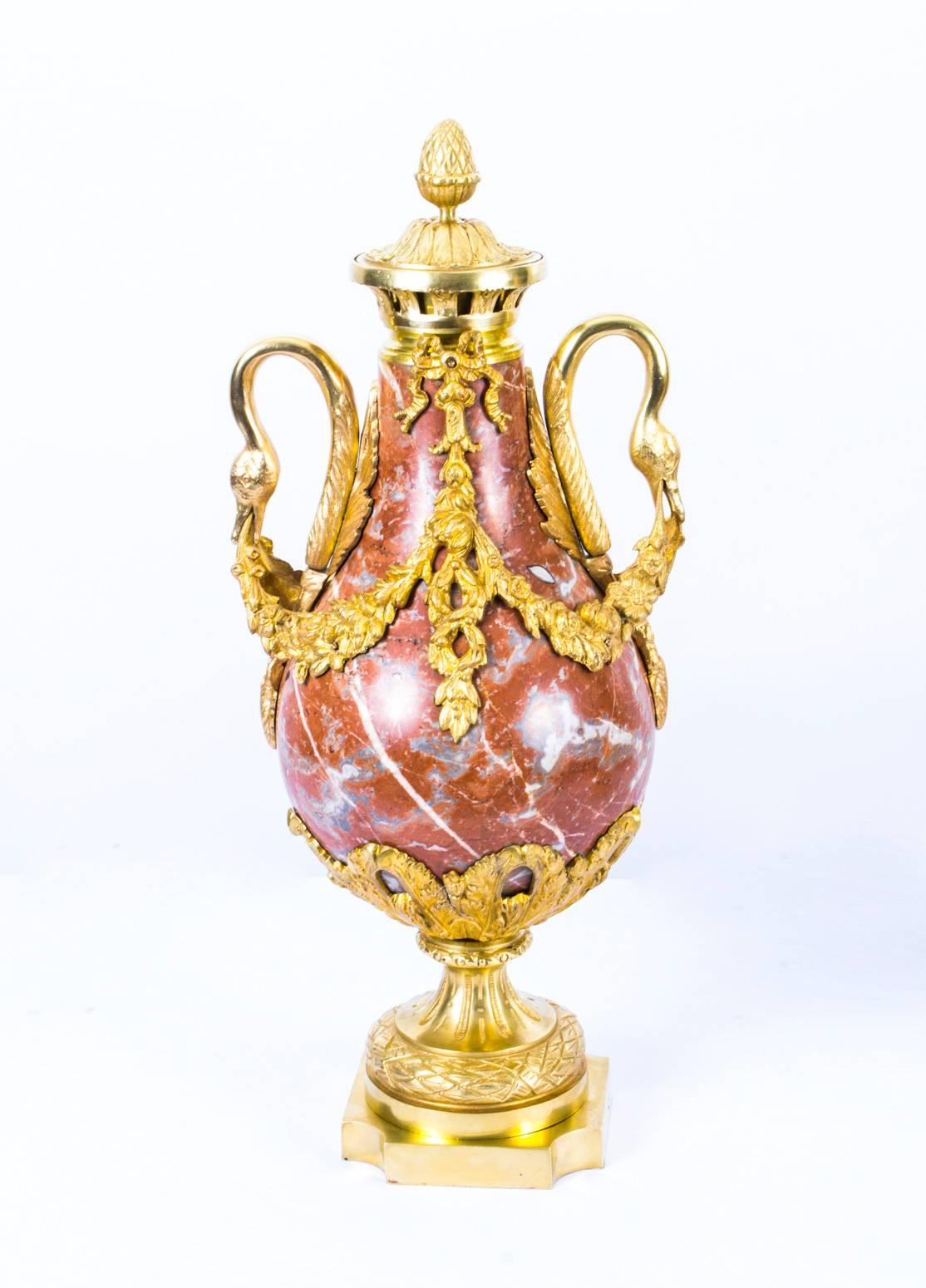 This is a lovely antique pair of French marble and gilded bronze urns in the Louis XV manner and dating from, circa 1860.

They are made of rouge marble, which has a delightful variegated pattern and gilded bronze, otherwise known as ormolu.

They