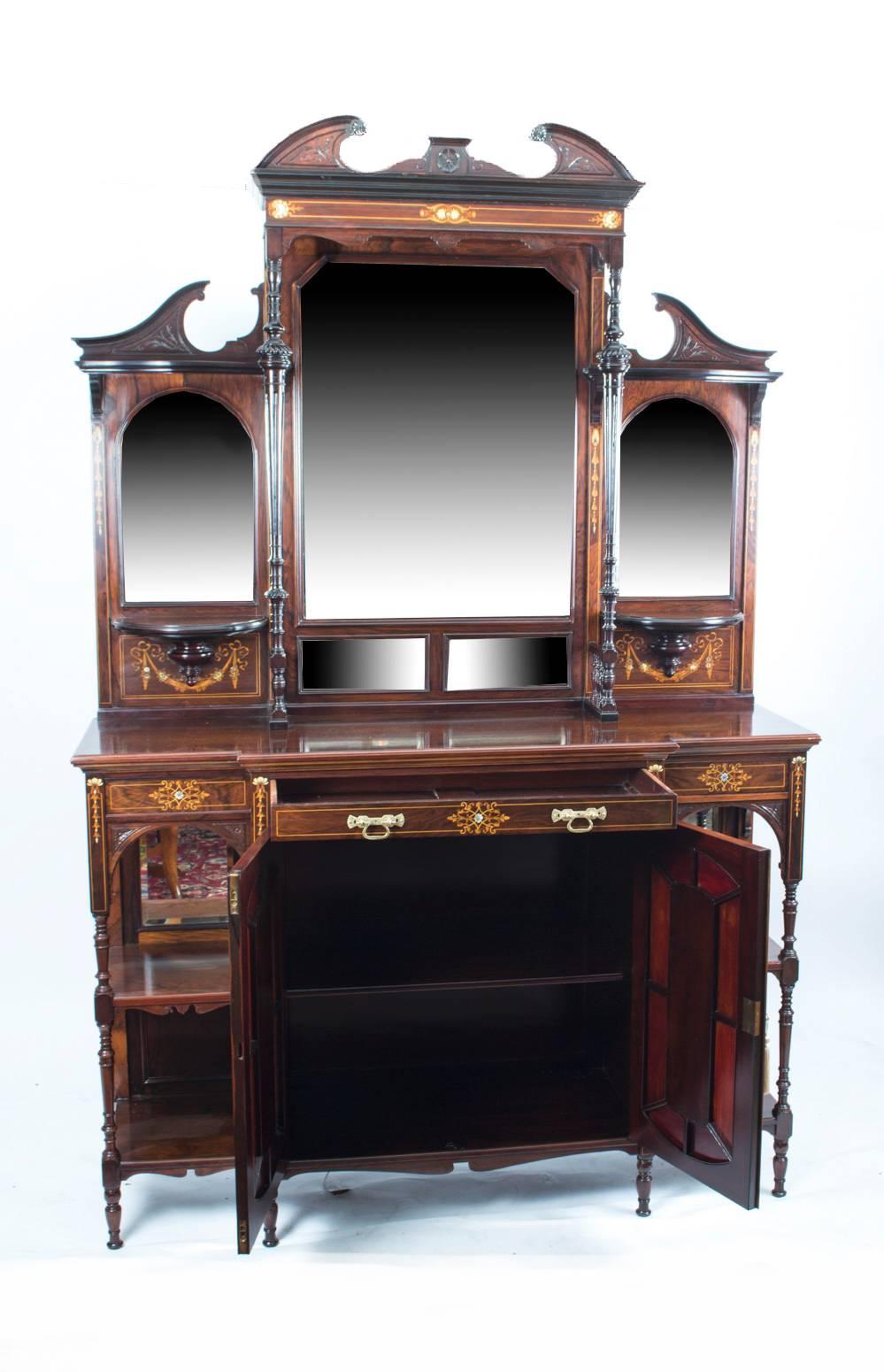 This is a stunning antique English Edwardian inlaid rosewood breakfront side cabinet with mirrored back and door panels and raised on slender turned supports, circa 1890 in date.

This cabinet is of the very highest quality with exquisite hand-cut