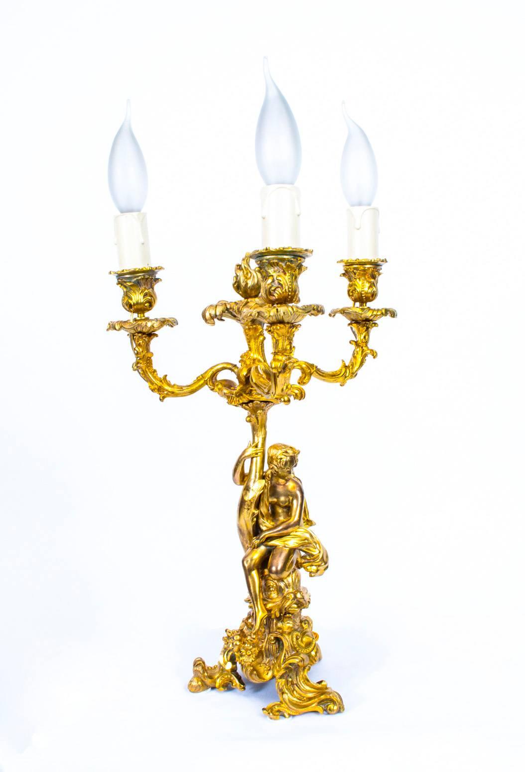 A gorgeous fine quality pair of antique Rococo ormolu three-light candelabra that have been later wired for electricity, in the Classic French manner, circa 1860 in date.

The beautifully sculpted and tooled gilded bronze candelabra feature a pair