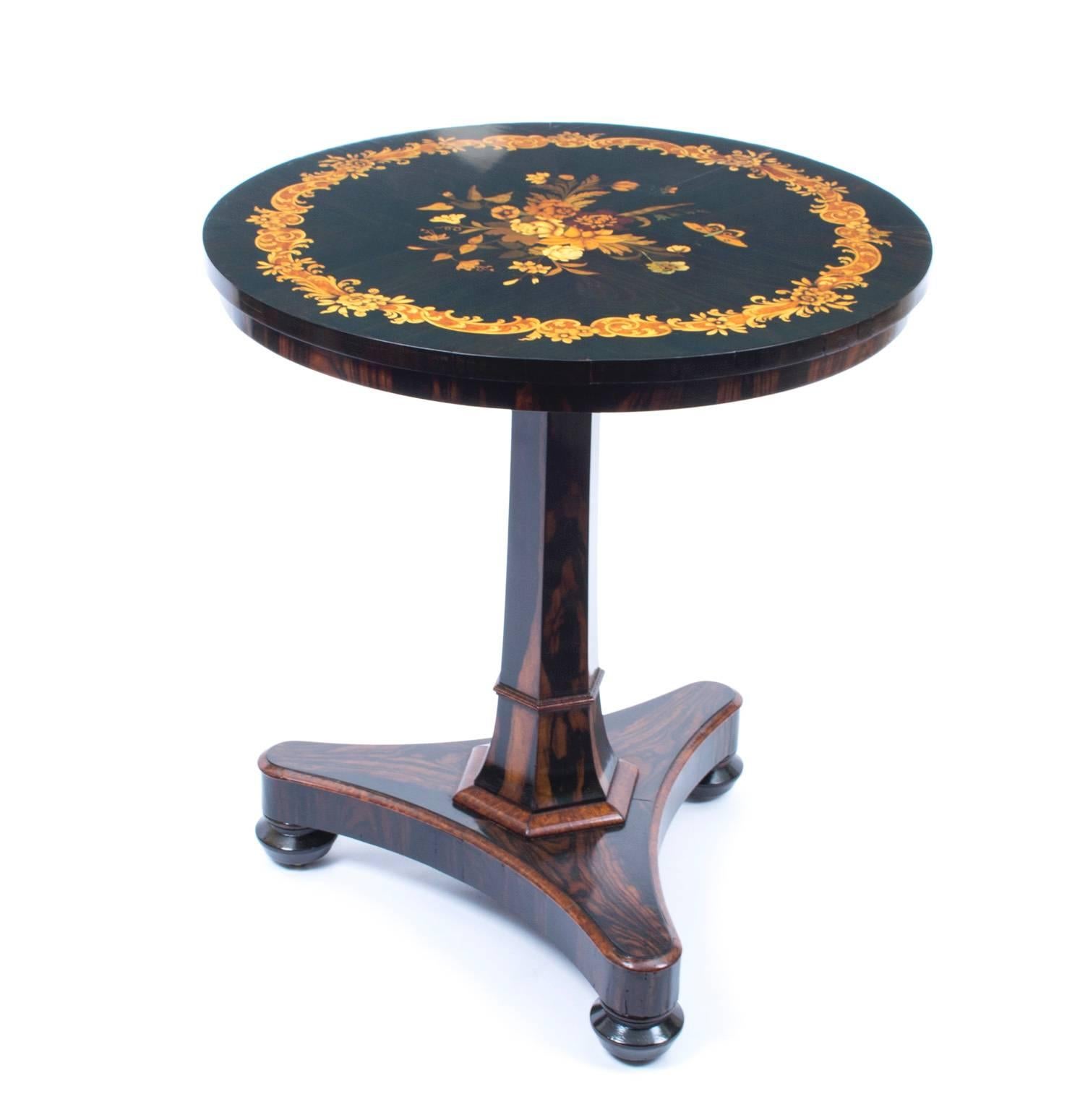 This elegantly proportioned antique Regency occasional table is circa 1825 in date.

This table has been masterfully crafted in coromandel wood and the circular top masterfully inlaid with a beautiful floral marquetry spray and butterfly.

It is