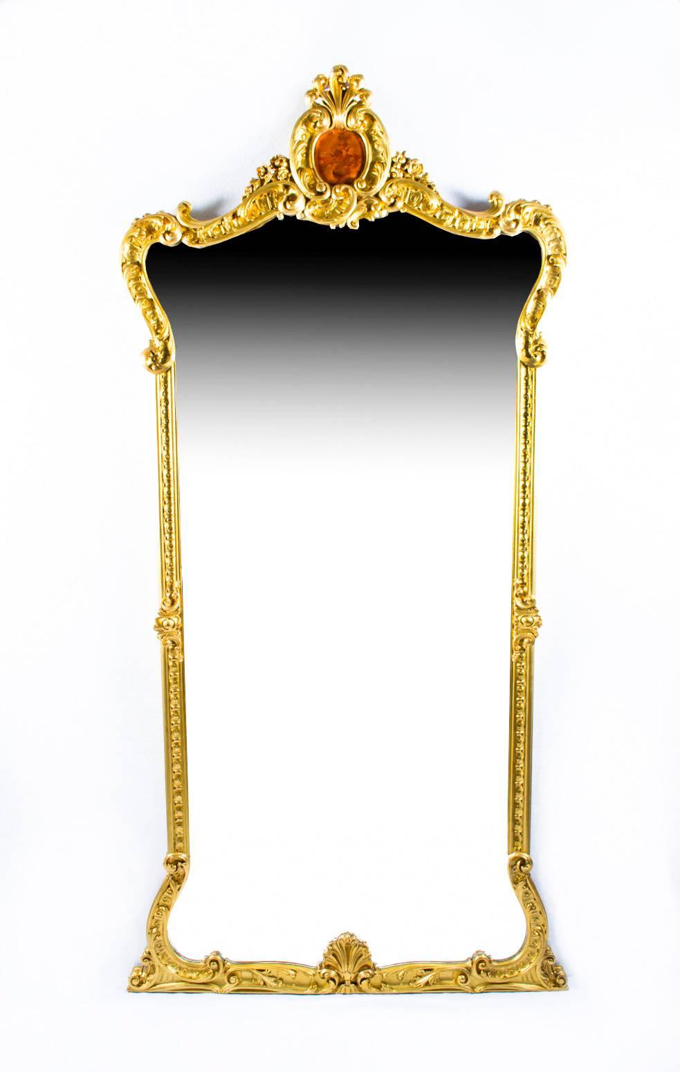 This is a monumental pair of 2.5 metre high antique Louis XV style French giltwood pier mirrors with stunning hand-carved floral decoration, circa 1890 in date.

The arched mirror plates are elegantly framed by hand-carved 'C'-scroll corners with