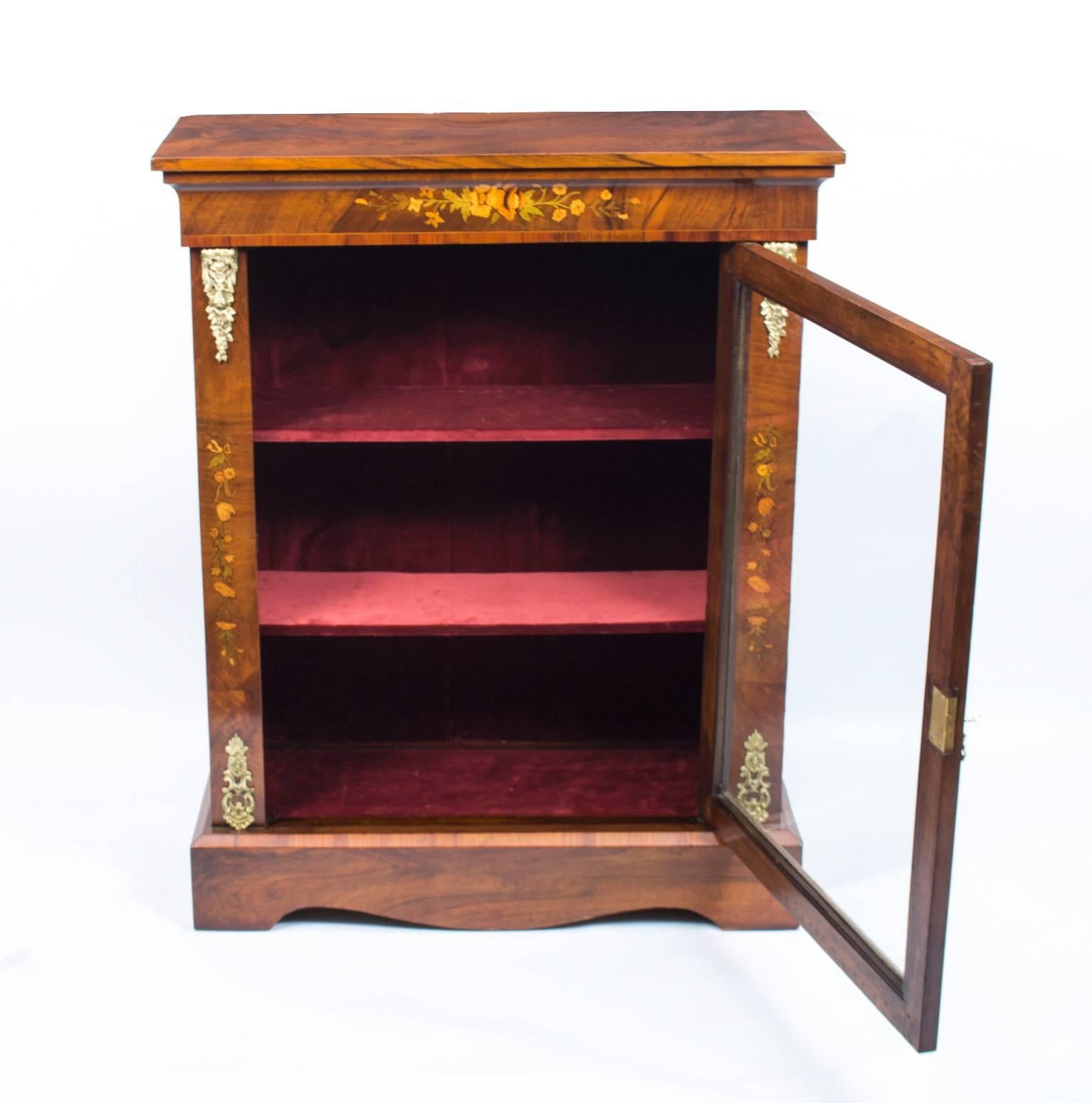 This is a beautiful antique Victorian pier cabinet, circa 1870 in date.

It has been accomplished in burr walnut with fabulous floral marquetry decoration.

Adding to its truly unique character it is decorated with exquisite gilded ormolu mounts