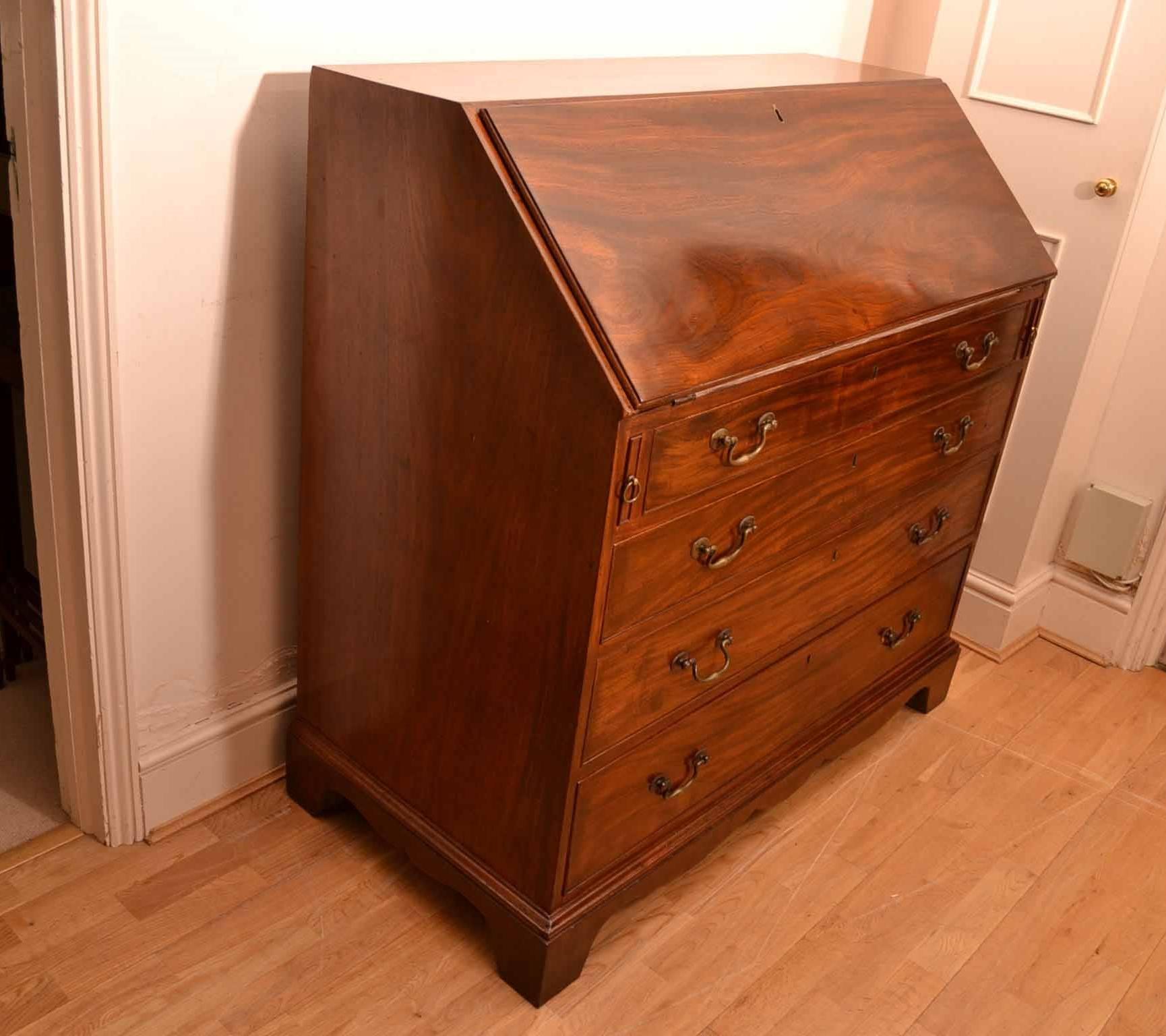 This is an antique mahogany George III bureau with a beautiful fitted interior, circa 1780 in date.
This magnificent piece is made of the finest flame mahogany. There are four large and spacious full width drawers. The interior has four small