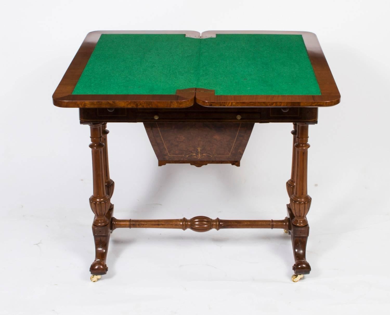 This is a fabulous antique Victorian burr walnut games and work table, circa 1870 in date.

It is made of beautiful burr walnut that has elegant satinwood line inlaid marquetry decoration.

The hinged top opens to reveal a fabulous green baized