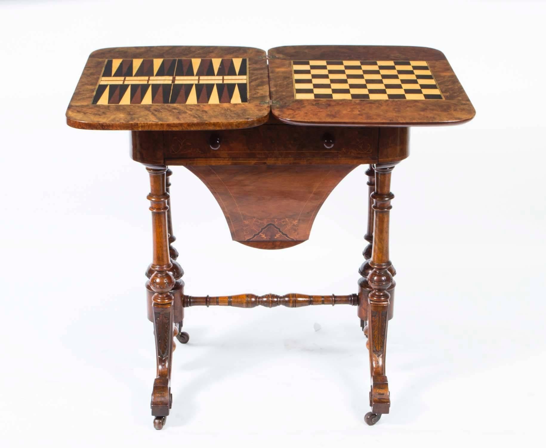 This is a fabulous antique Victorian burr walnut games and work table, circa 1870 in date.

It is made of beautiful burr walnut that has elegant satinwood line inlaid decoration with ebonized highlights.

The hinged top opens to reveal a