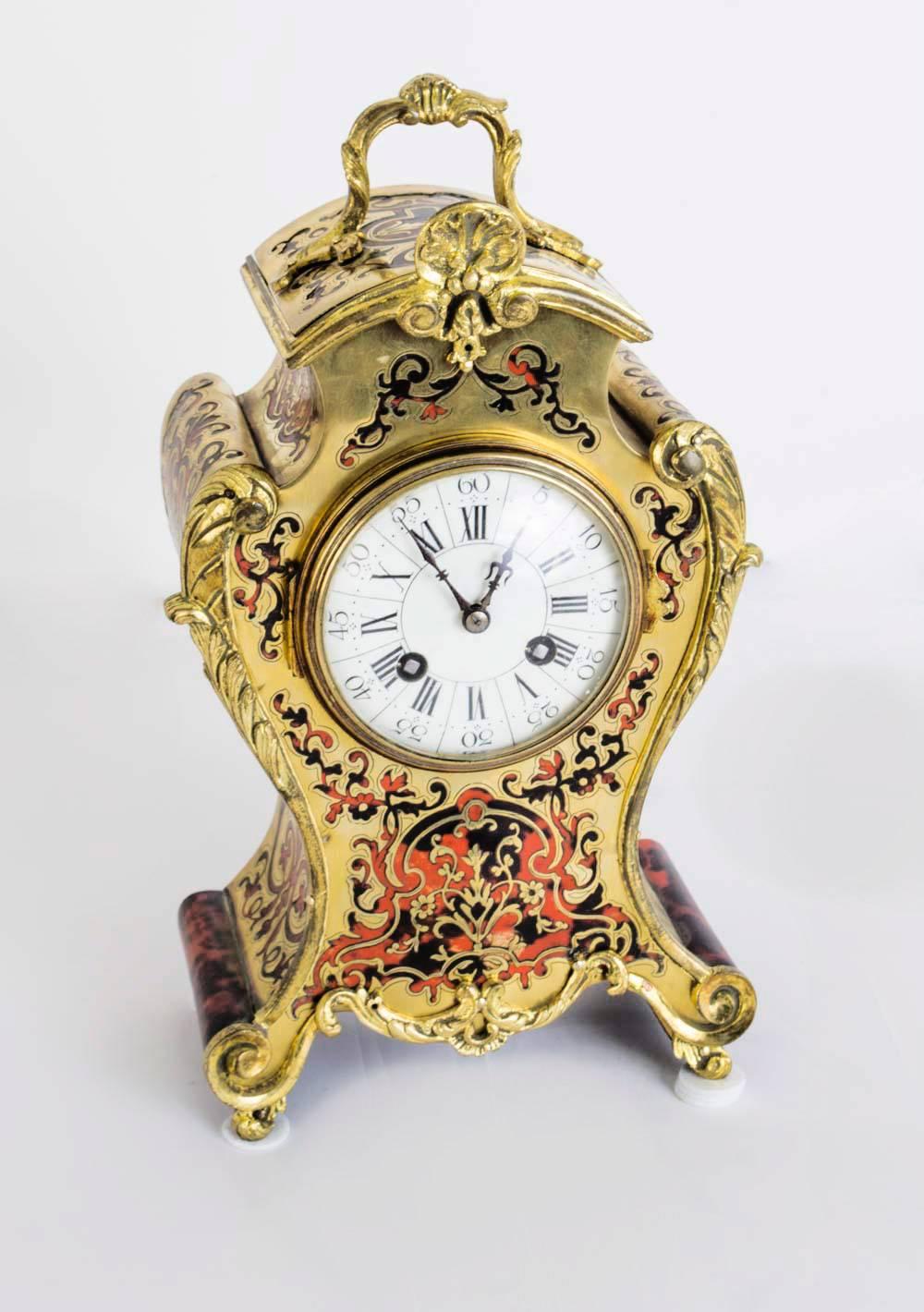 This is a fabulous antique French shell red Boulle cut brass ormolu mantel clock, circa 1880 in date.

The top has a brass handle above scrolling sides with acanthus decoration.

The movement is stamped 10066 & 46.

It has a white