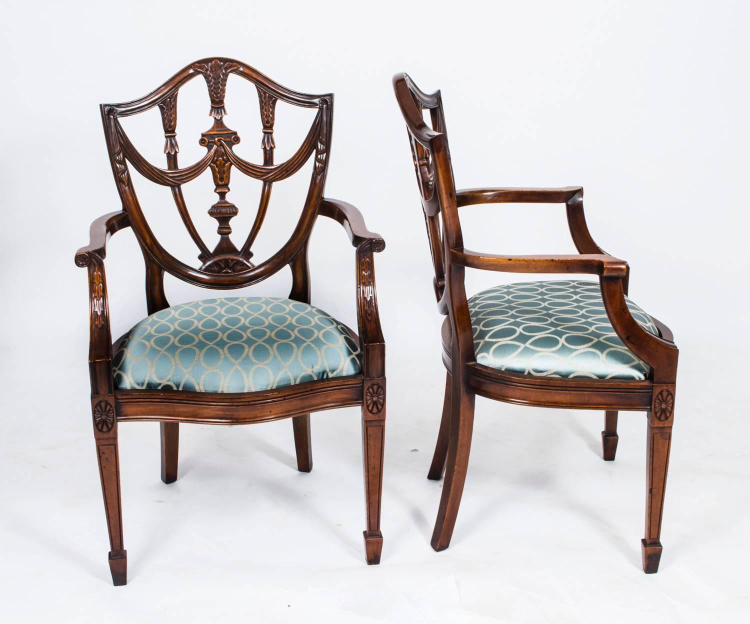 This is an absolutely fantastic vintage set of fourteen Federal style shield back dining chairs, dating from the second half of the 20th century.

These chairs have been masterfully crafted in beautiful solid mahogany with hand carved decoration