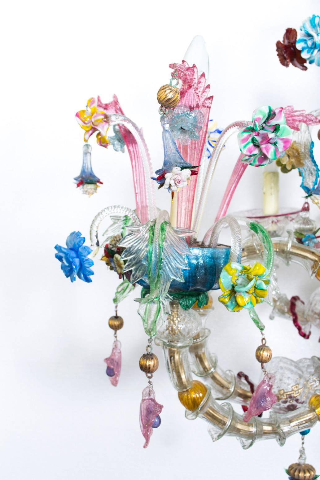This is a stunning antique Venetian Murano crystal fourteen-light chandelier dating from the mid-19th century.

Composed entirely of handblown clear and coloured glass this impressive chandelier has a central urn issuing eight lower branches
