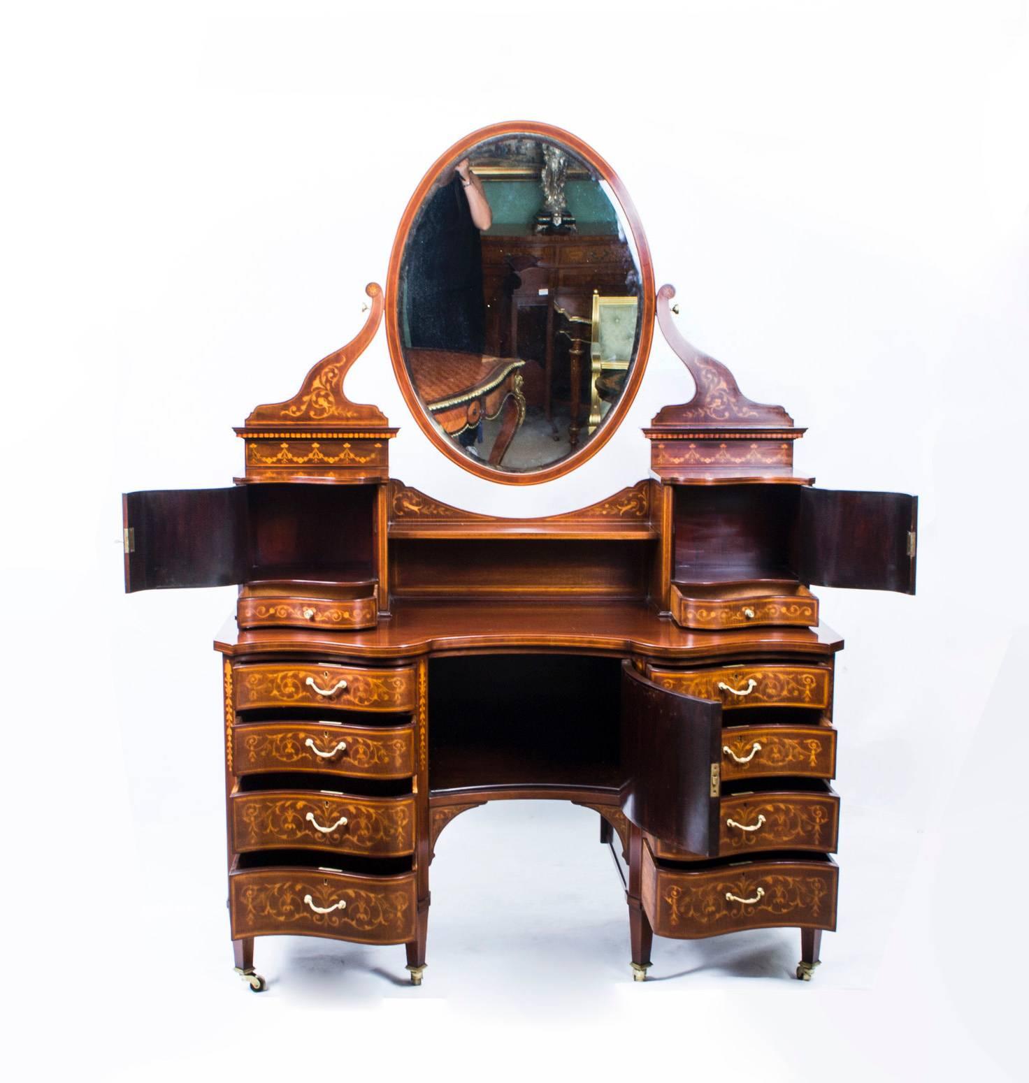 This is a spectacular antique late Victorian mahogany and floral marquetry dressing table by the renowned cabinet maker and retailer Edwards & Roberts, circa 1880 in date.

It is inlaid with a beautiful marquetry of scrolls and foliage in