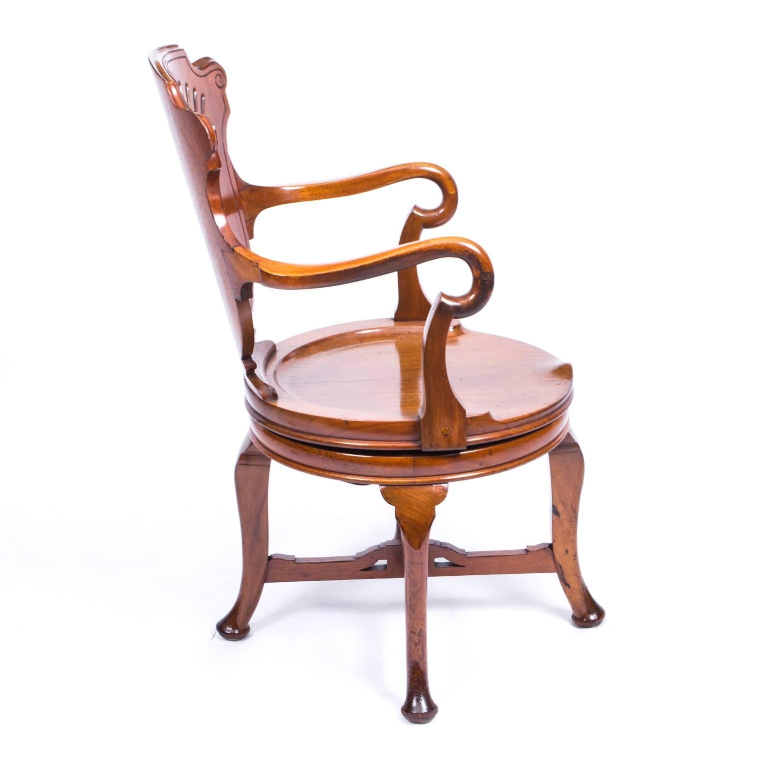 This is a superb antique late 19th century walnut revolving desk chair. 

It is made of very high quality solid solid walnut with a beautiful and decorative shell carved back with shepherd's crook arms and saddle seat. It is raised on cabriole