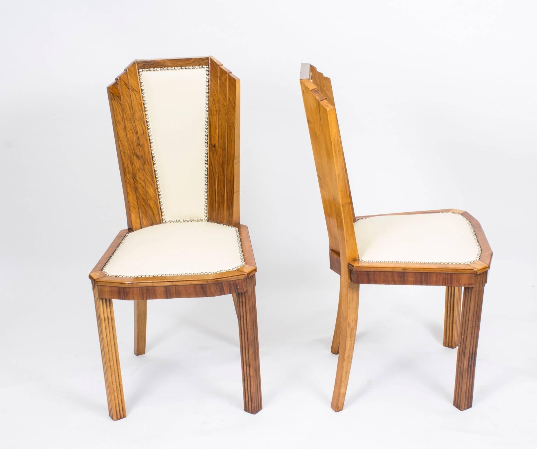 This is a stunning set of six antique Art Deco skyscraper burr walnut dining chairs, circa 1930 in date.

They have been reupholstered in fabulous white leather with chrome studs.

They are of striking burr walnut and feature an architectural