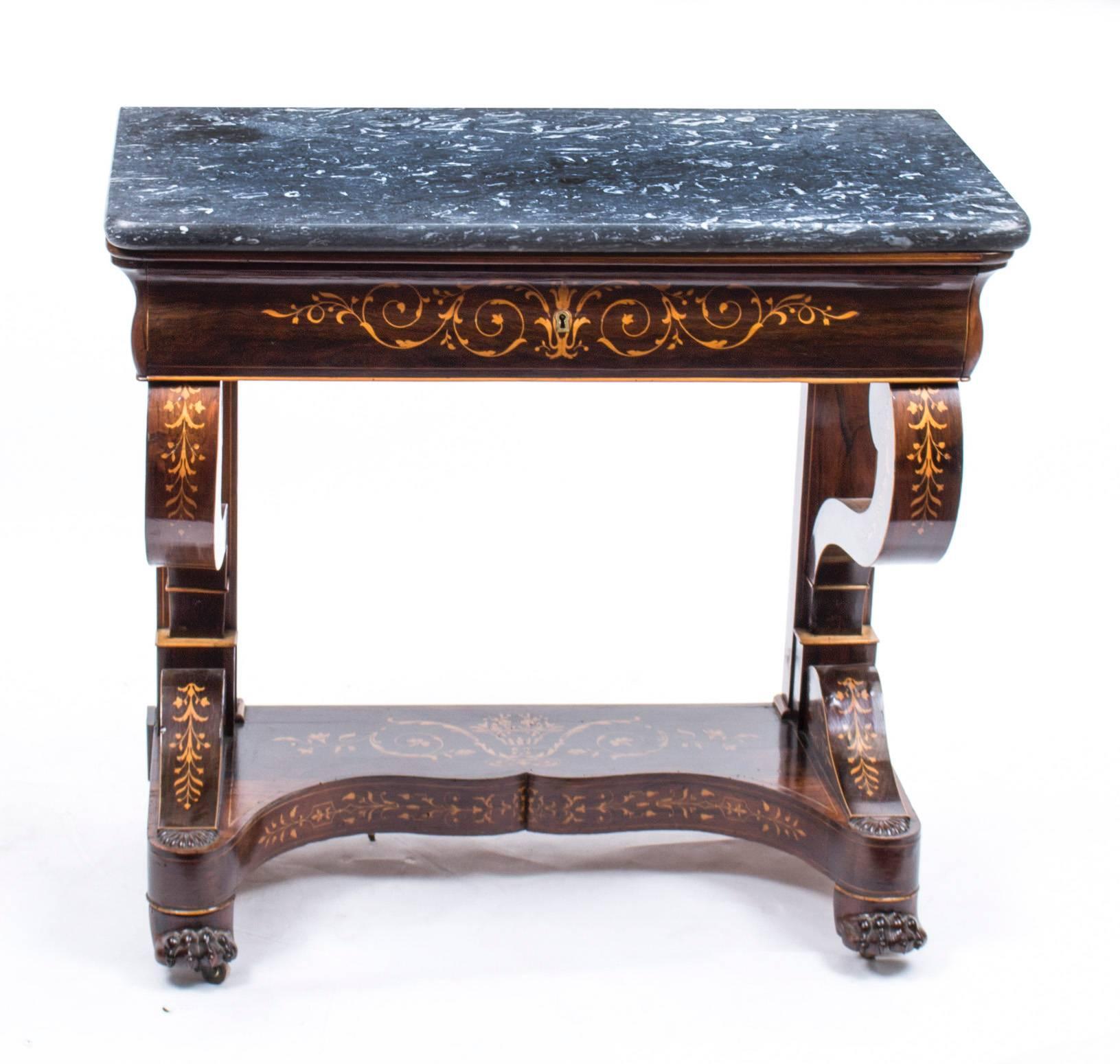 This is a very elegant and petite antique French Charles X period finely figured rosewood console table with superb inlaid satinwood marquetry decoration typical of the period, circa 1830 in date.

This beautiful console table retains its original