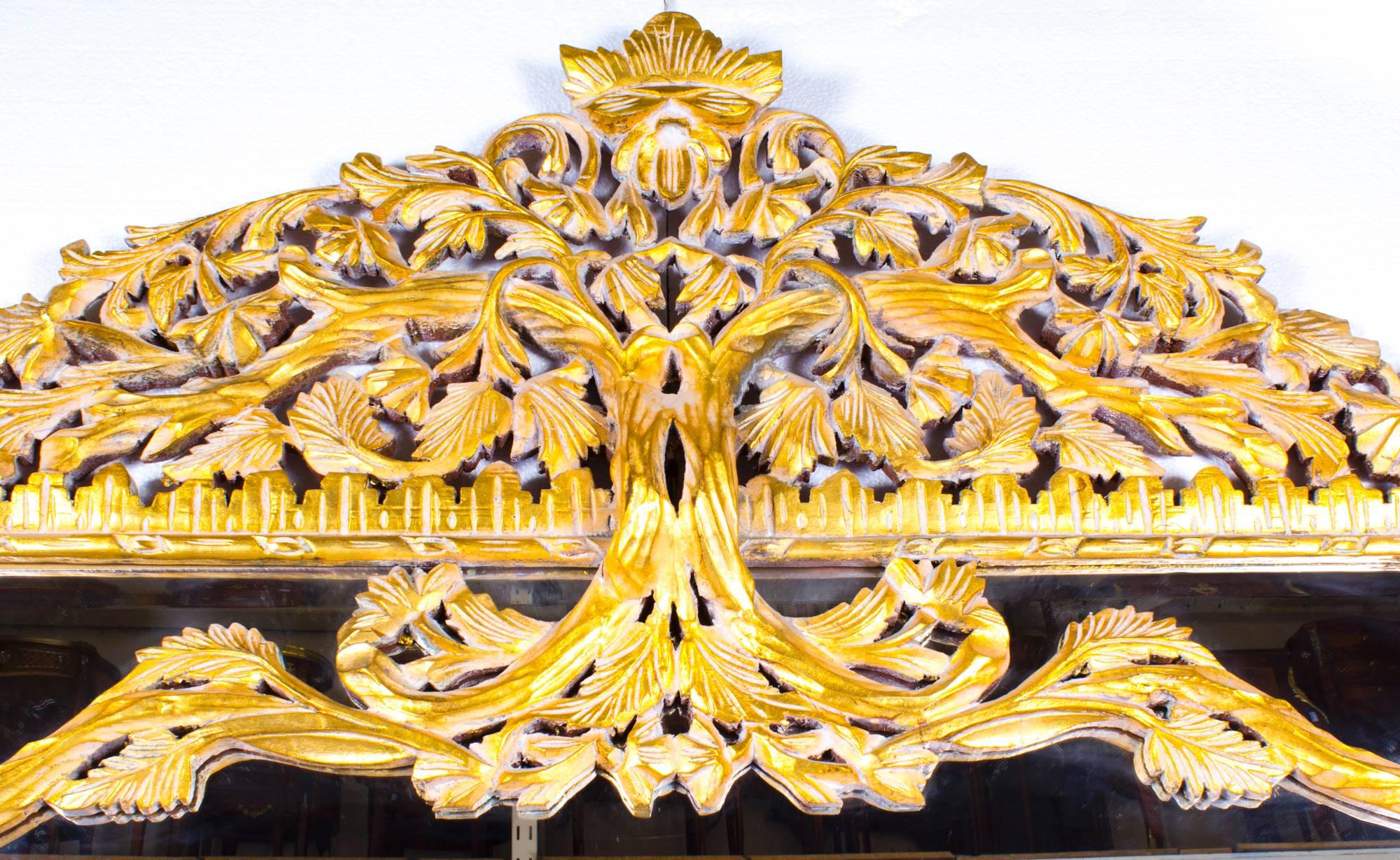 This is a beautiful and highly decorative large Italian rectangular giltwood mirror with foliate trailing vine hand carved and gilded decoration, dating from the second half of the 20th century.

With superb hand carved gilt wood and bevelled
