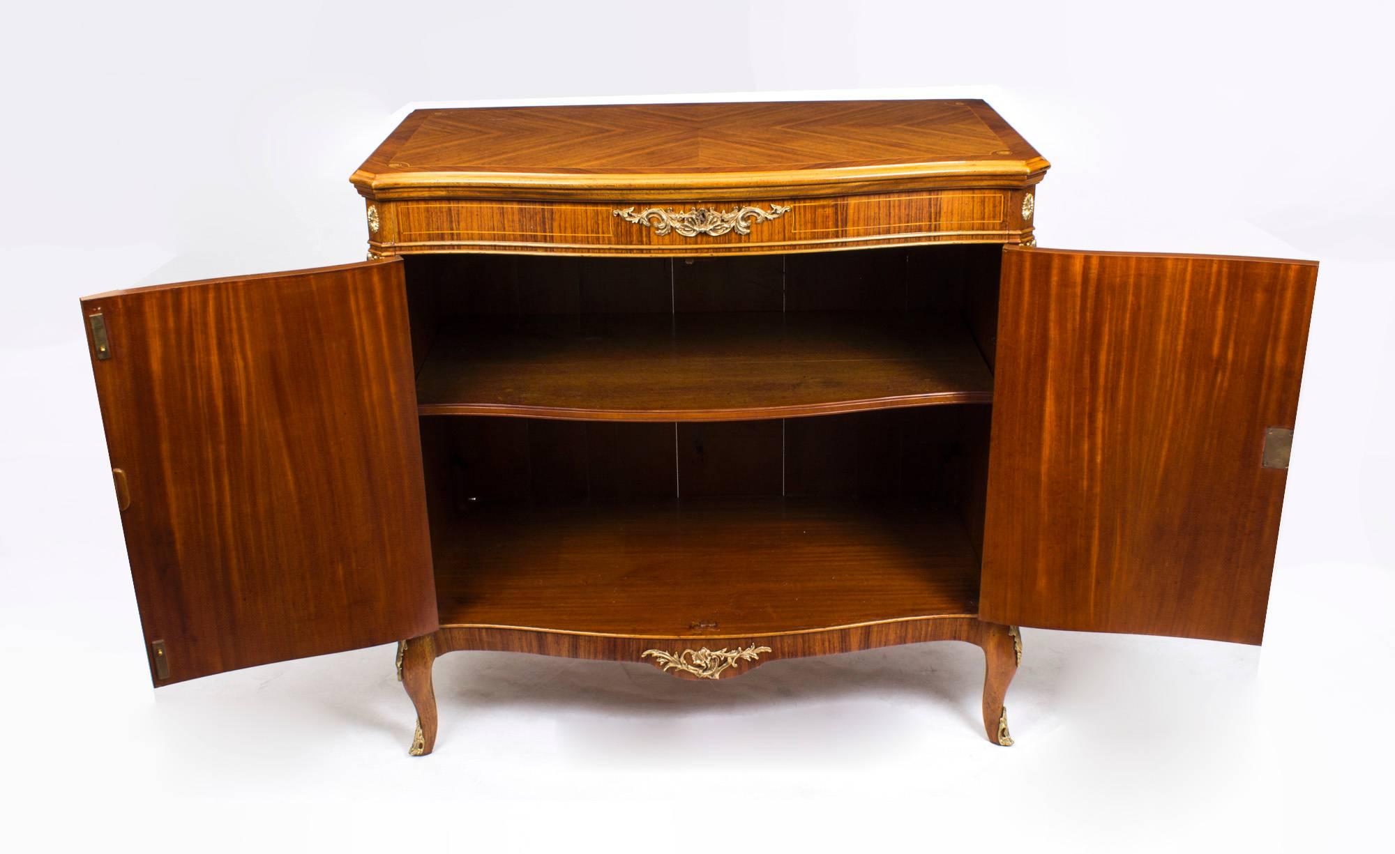 This is a fantastic vintage burr walnut side cabinet with fabulous ormolu mounts, exquisite floral marquetry decoration, circa 1950 in date and by the renowned makers of bespoke furniture, Epstein Bros.

The doors open to reveal a cupboard with a