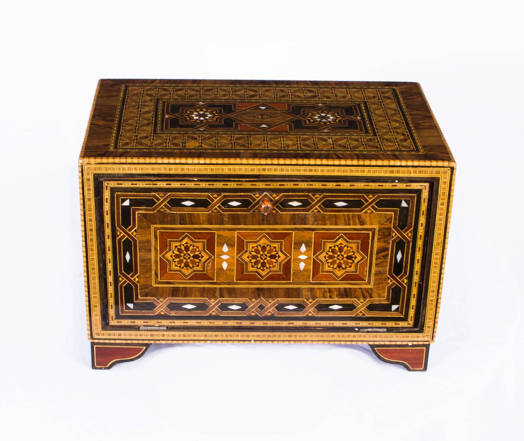 This is a superb intricately inlaid Islamic table cabinet decorated with mother-of-pearl and specimen woods from Damascus and dating from the second quarter of the 20th century.

This beautifully detailed inlaid parquetry cabinet features