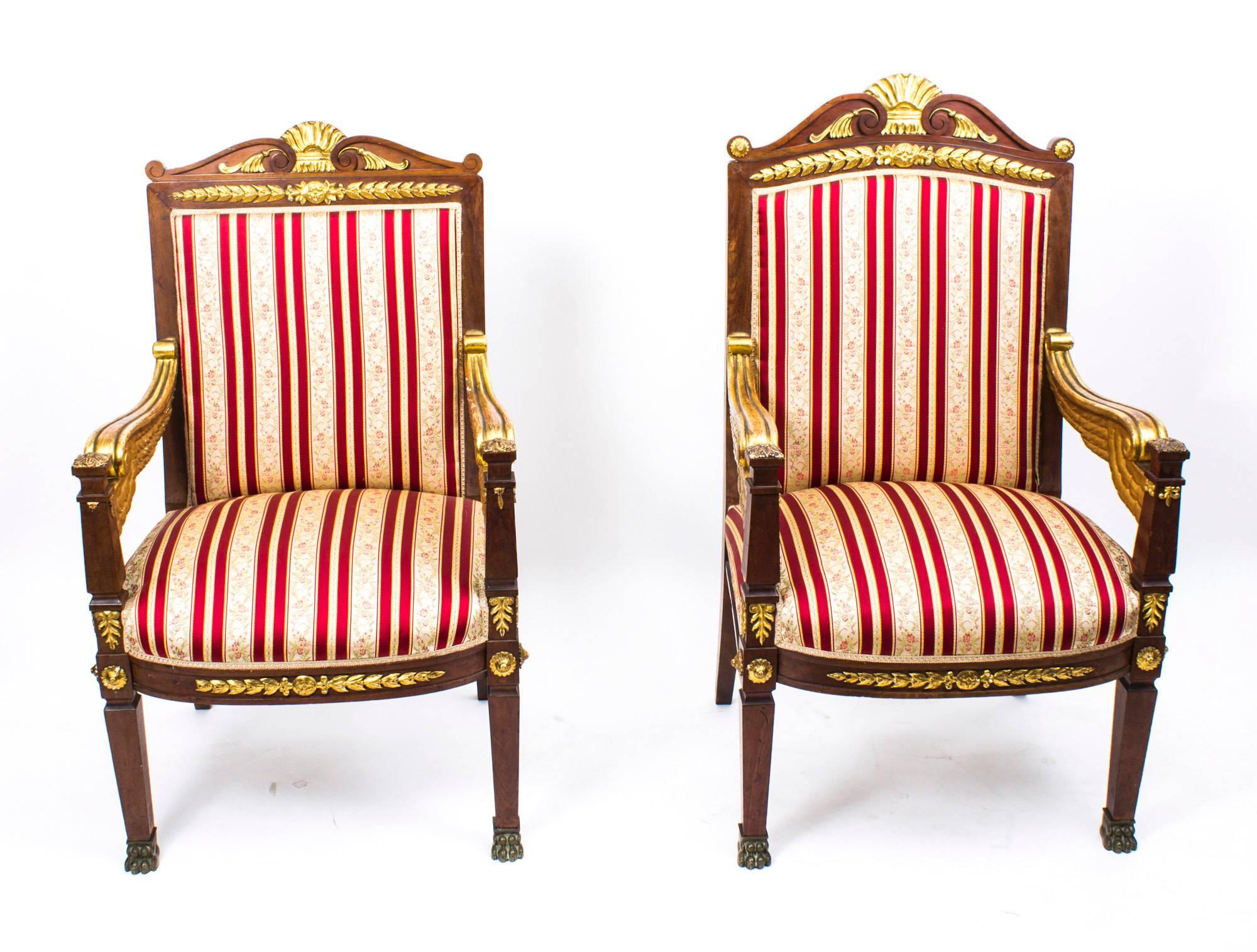 This is a fine companion pair of hand carved and gilded Napoleon III solid mahogany French Empire armchairs, circa 1870 in date.

These rare ladies and gents companion chair, feature stepped block front legs which terminate in ormolu lion's paw
