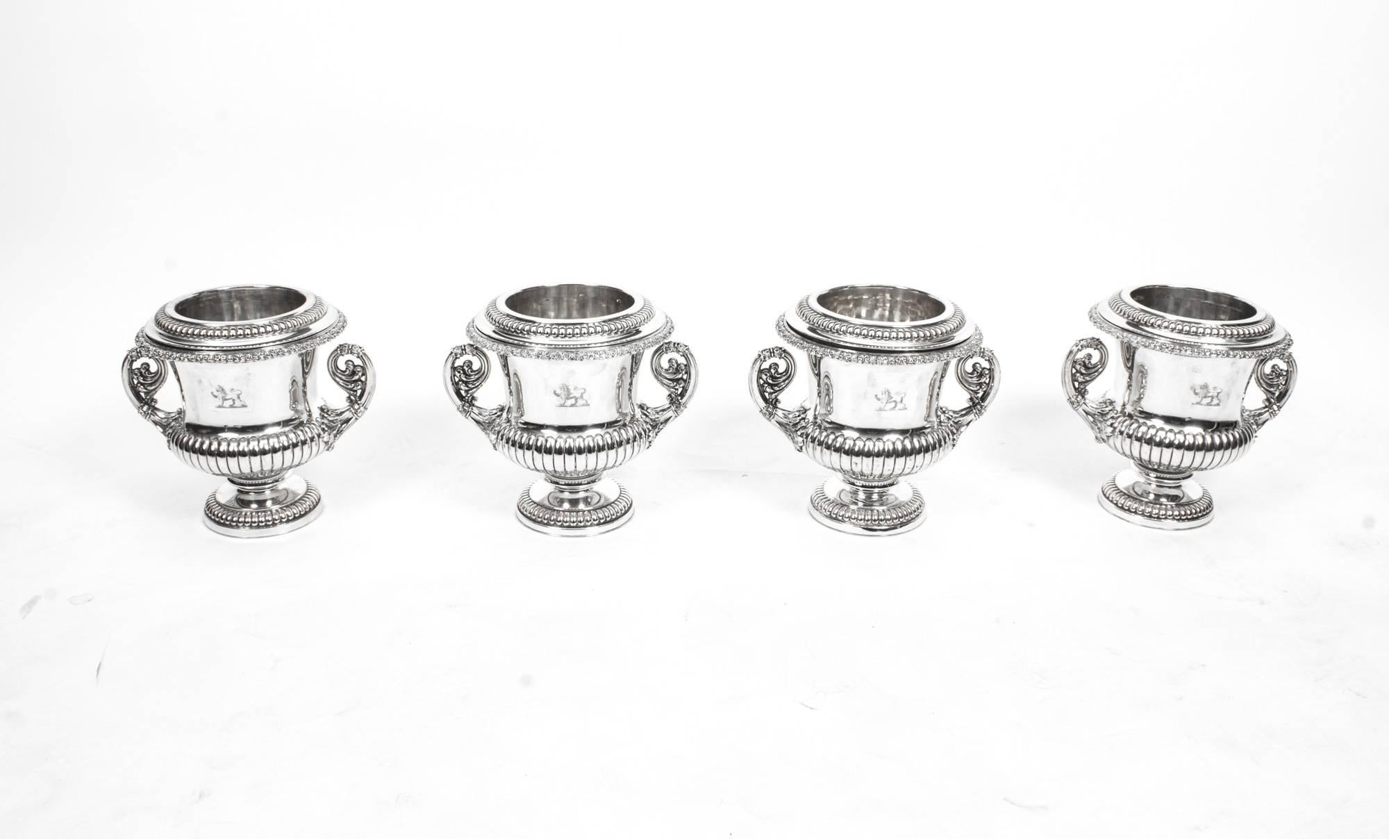 This is a wonderful and rare set of four antique English Old Sheffield Plate, silver on copper, Regency wine coolers, circa 1820 in date.

Each is fitted with an exceptional pair of decorative handles embellished with chased leaf