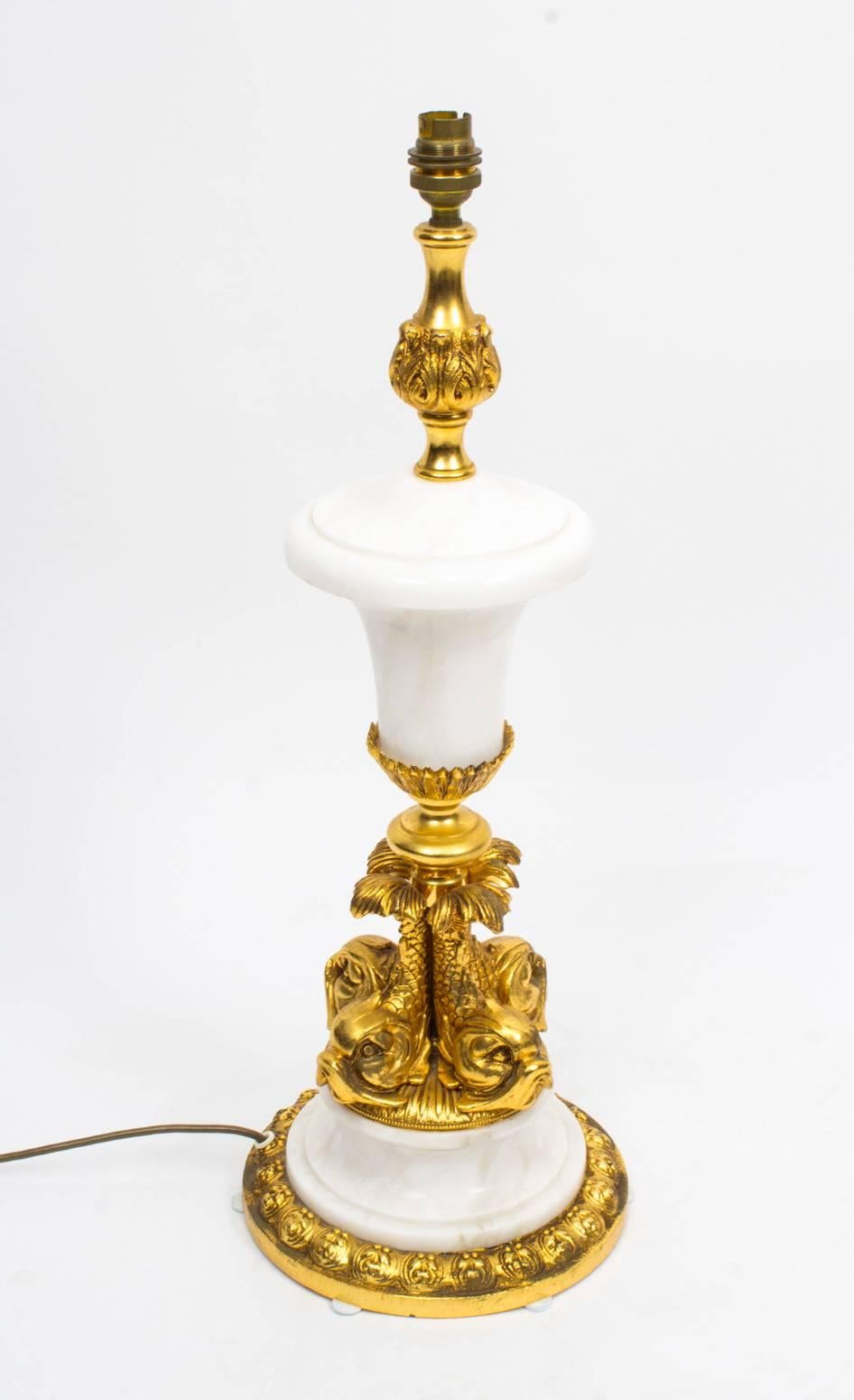 This is a truly superb large white marble and ormolu Louis Revival table lamp, dating from the last quarter of the 20th century.

The central column stands on four ormolu dolphins raised on a marble socle that rests on an ormolu base.

The