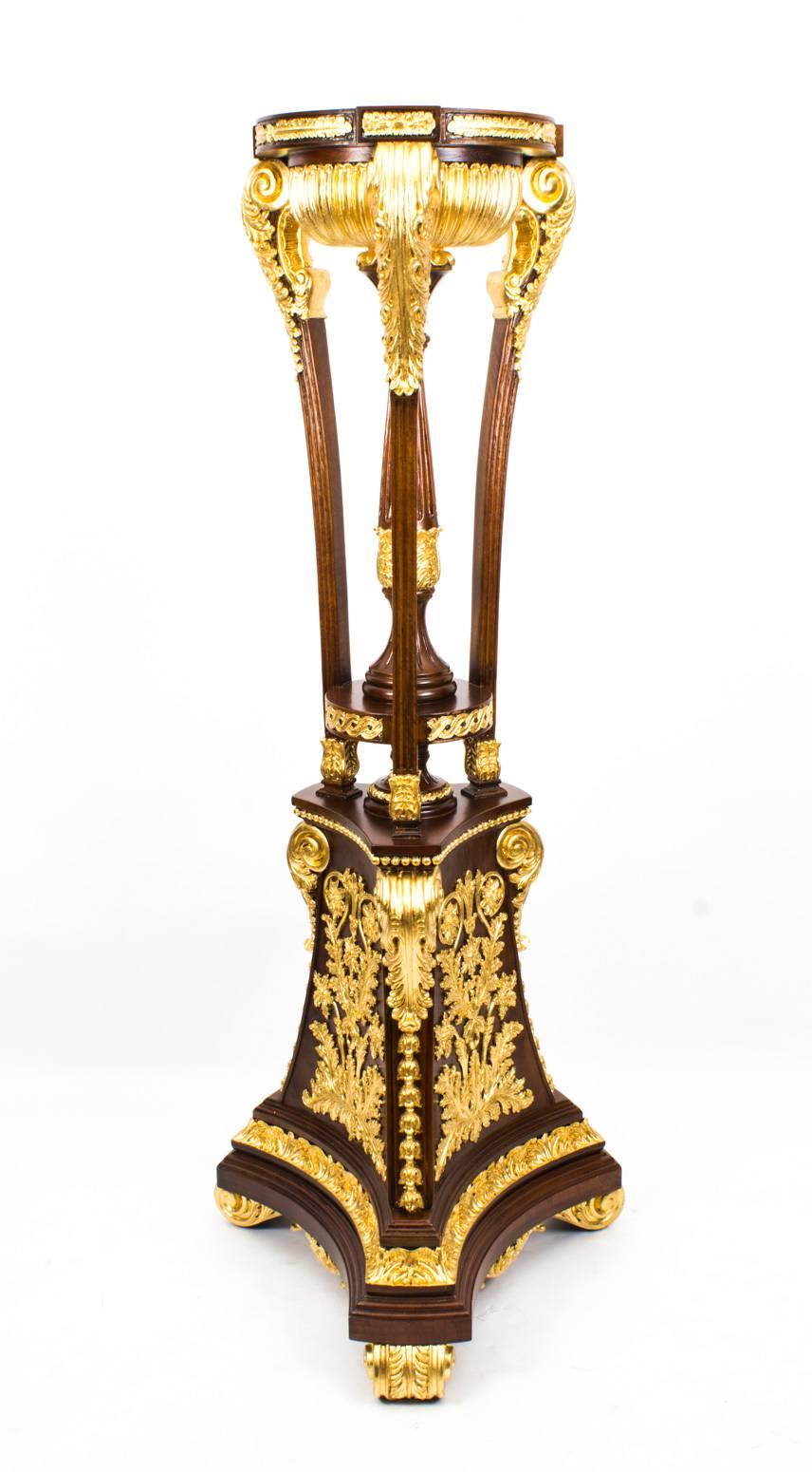 This extraordinary monumental pair of 6ft mahogany and giltwood torchers of impressive size in fabulous Empire style, date from the last quarter of the 20th century. 

The torchers are supported by tall tripod bases on acanthus scroll feet worked