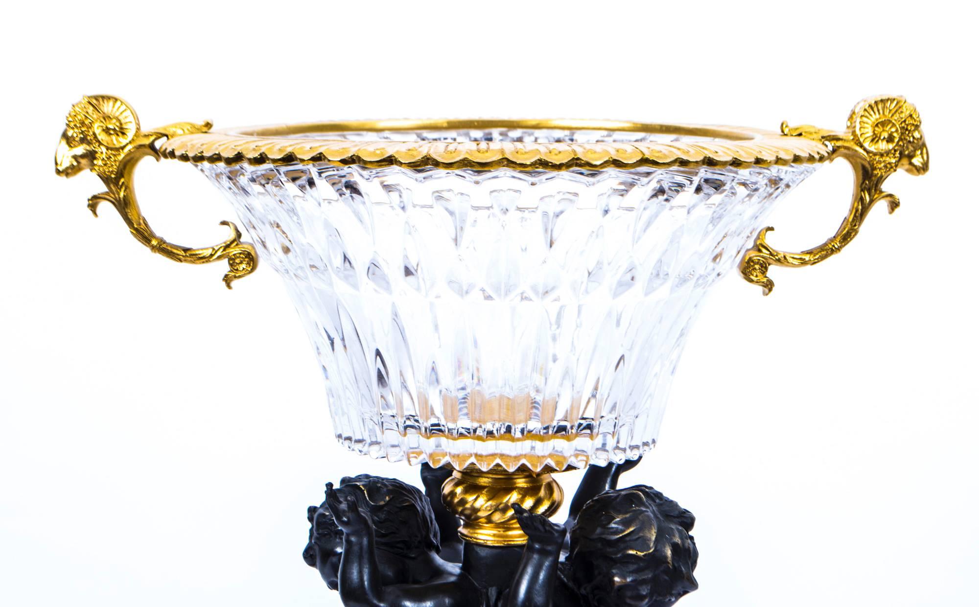 A beautiful cut-glass, ormolu, and bronze cherub centrepiece from the last quarter of the 20th century.

The craftsmanship is second to none throughout all aspects of this stunning piece and it is sure to add an unparalleled touch of class to any