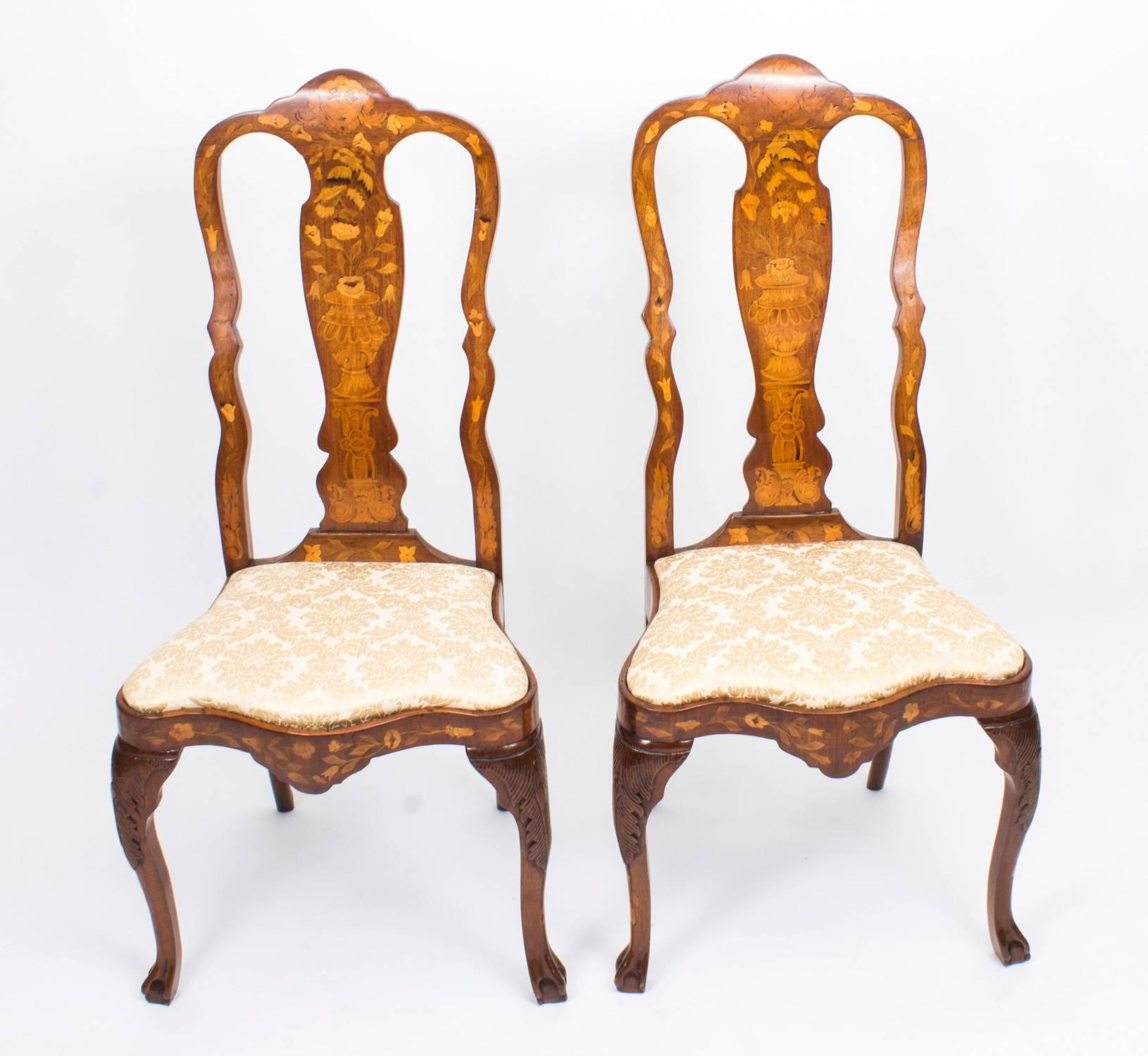 This is a beautiful and rare antique set of eight high backed Dutch walnut and floral marquetry dining chairs. The set compromises two armchairs and six side chairs, all circa 1780 in date. The chairs have been skillfully crafted from solid walnut