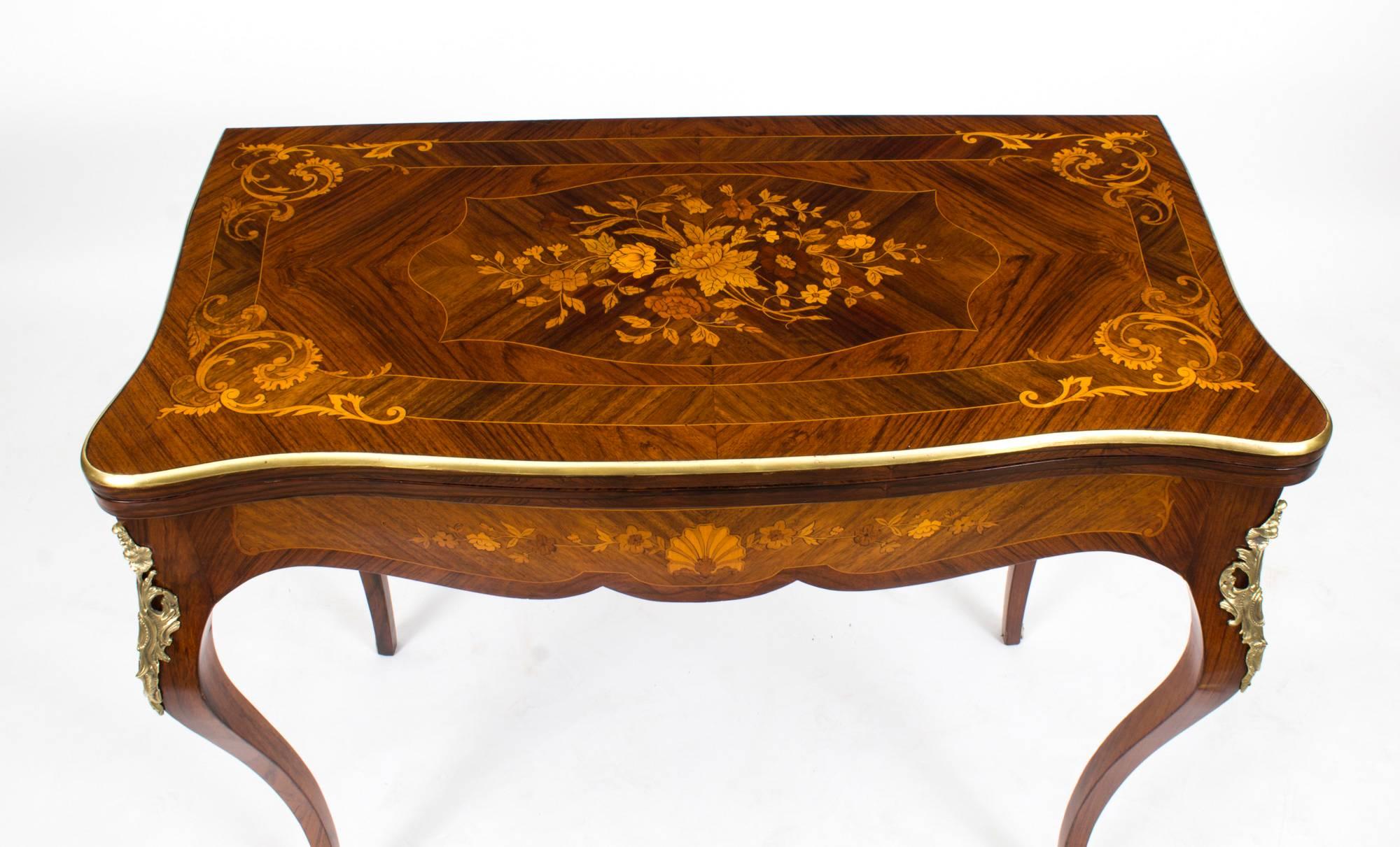 This is a stunning late 19th century antique French burr walnut and floral marquetry card table with ormolu mounts, circa 1880 in date.
 
The shaped burr walnut top has line inlay encompassing exquisite floral marquetry, and a stunning gilt bronze