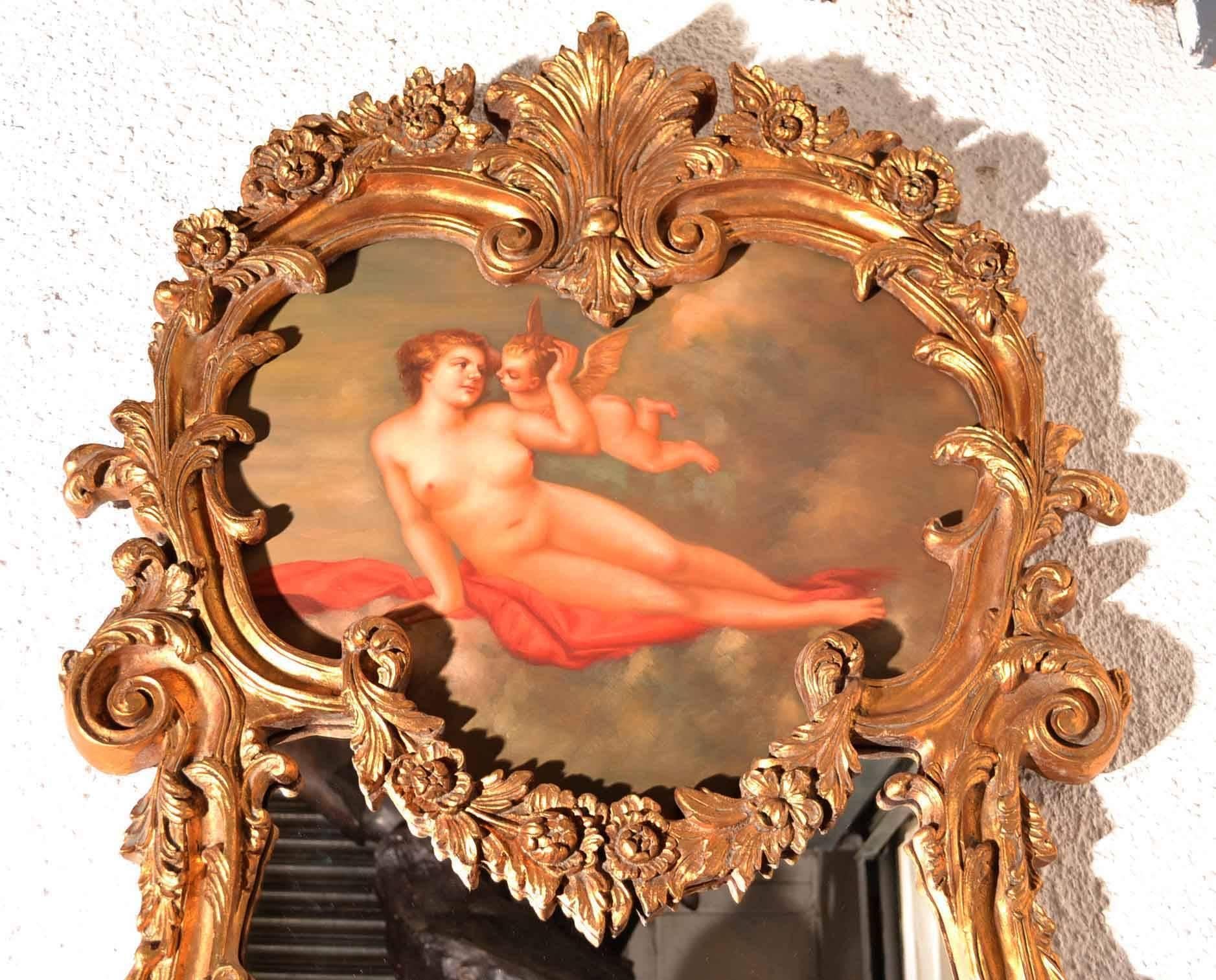 This is a beautiful and highly decorative Italian gilt mirror with a stunning hand-painted plaque depicting a Greek goddesses as a lovely cherub, dating from the last quarter of the 20th century.

The quality and craftsmanship of this stunning
