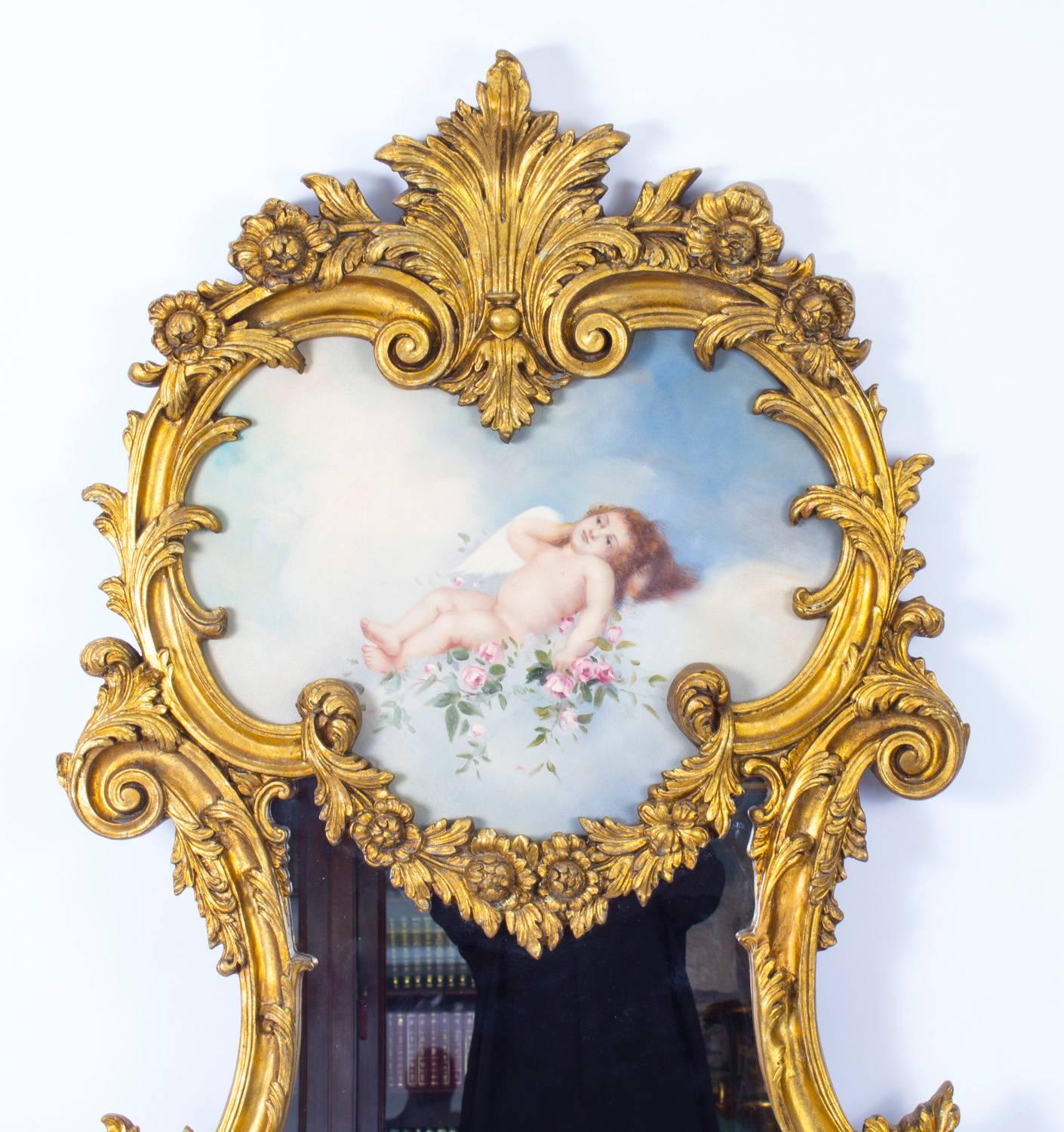 This is a beautiful and highly decorative Italian gilt mirror with a stunning hand-painted plaque depicting a cherub resting on a cloud, dating from the last quarter of the 20th century.

The quality and craftsmanship of this stunning piece are