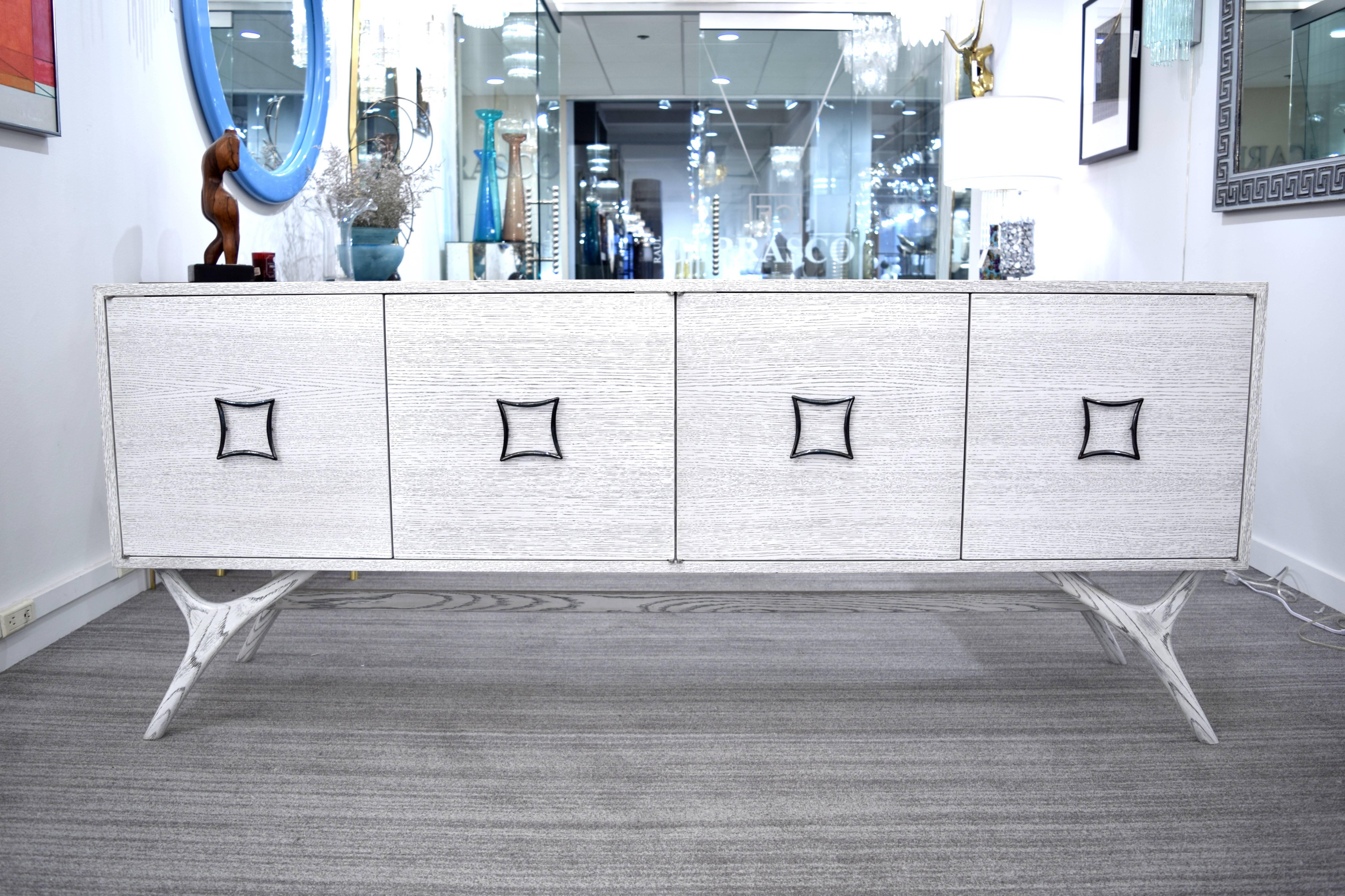 Exceptional four door credenza by Irwin Feld Design for CF Modern. Shown in a reversed white cerused oak with an antiqued brass hardware, we offer custom sizes and finishes. We can customize this piece to your specifications, add drawers and change