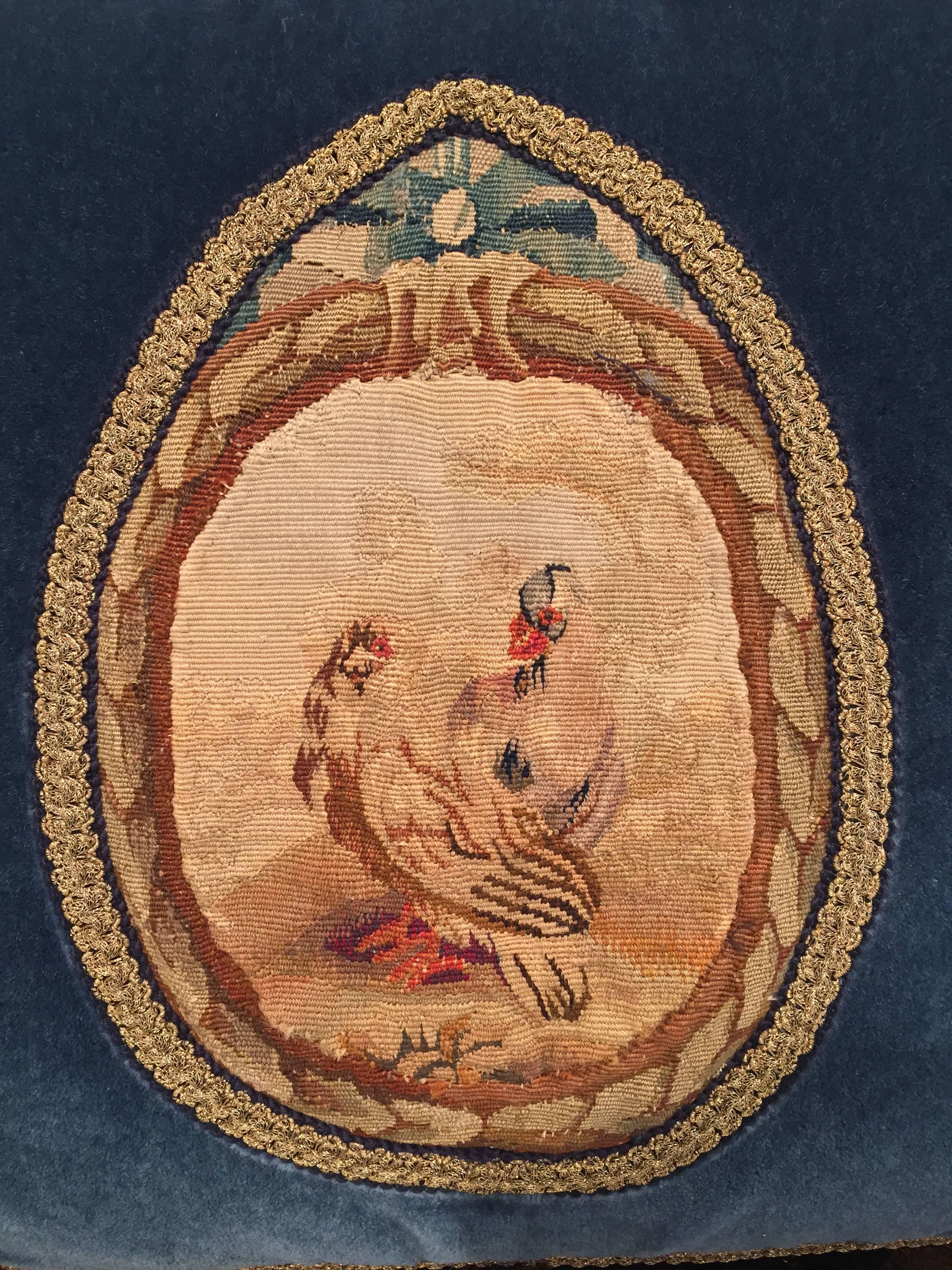 Decorate a bed or living room couch with this custom, blue velvet pillow. The square, plush pillow is made from scratch using an antique Aubusson tapestry medallion. The pillow design features a pair a chickens, and trims and tassels. The tapestry