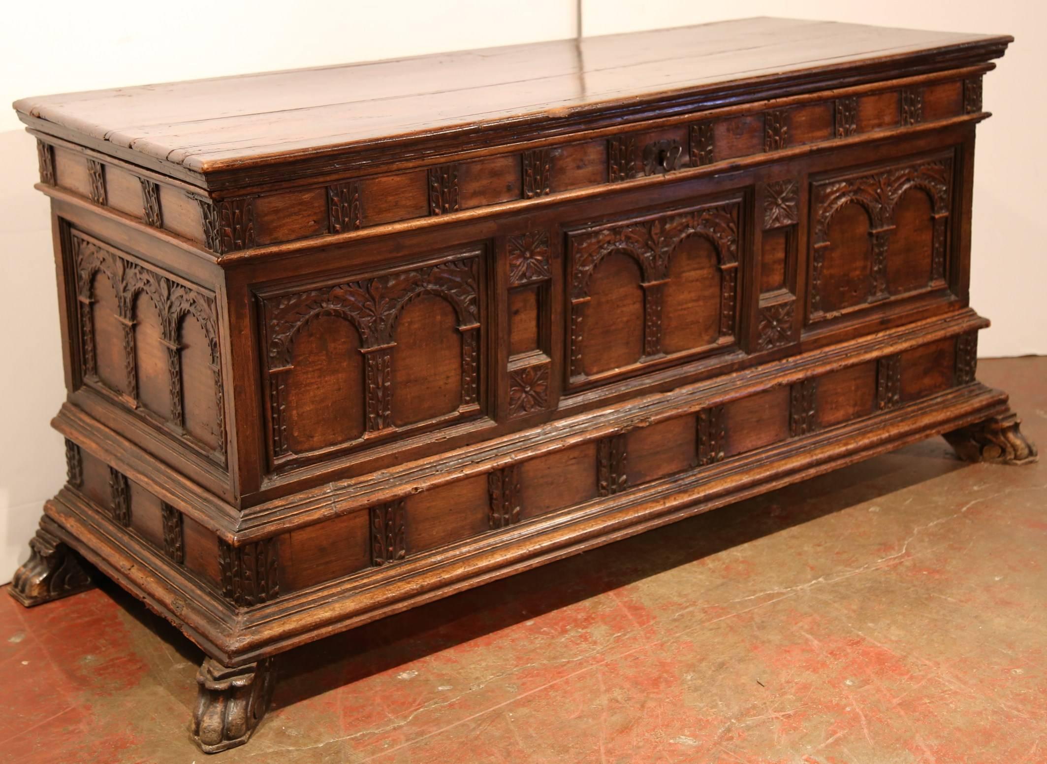 Antique carved walnut cassone coffer on paw feet from Italy, circa 1680, featuring beautiful carved panels on the front with paw feet at the base. Opened or closed because of the inside carved panel, this trunk can be used as a storage unit or as a