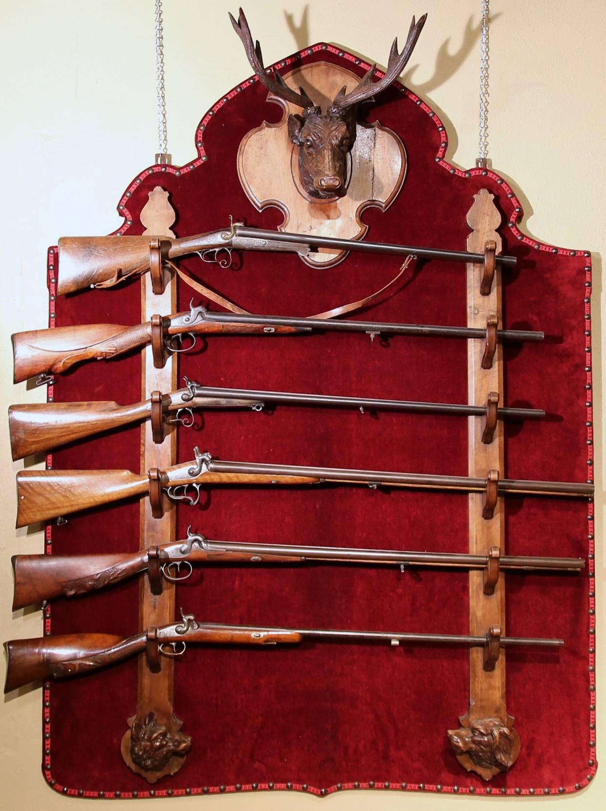 Grand antique gun display rack (or pool cue holder) from France or Switzerland, circa 1880. The shaped wall-mounted shelf will hold six guns; it features a nicely carved deer trophy with antlers on top and a pair of wood carved hunting dogs heads at