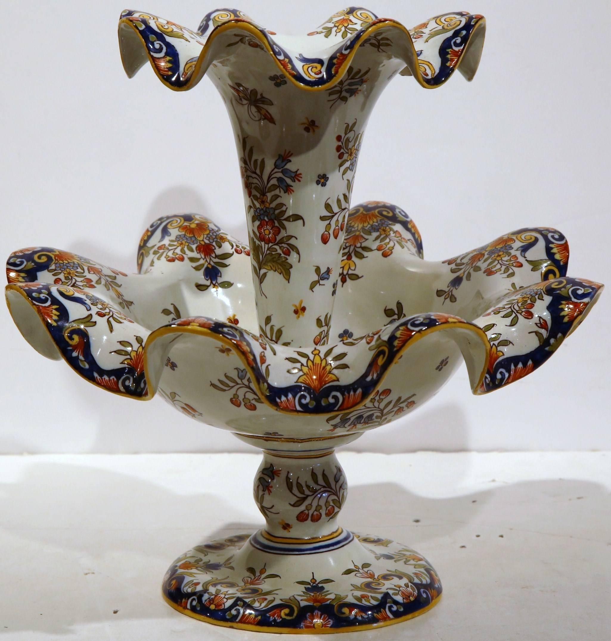 This large antique ceramic vase was created in Rouen, France, circa 1920. The two-tier centerpiece sits on a round base and features hand painted floral motifs in the yellow and blue palette. The ceramic flower holder is in excellent condition with