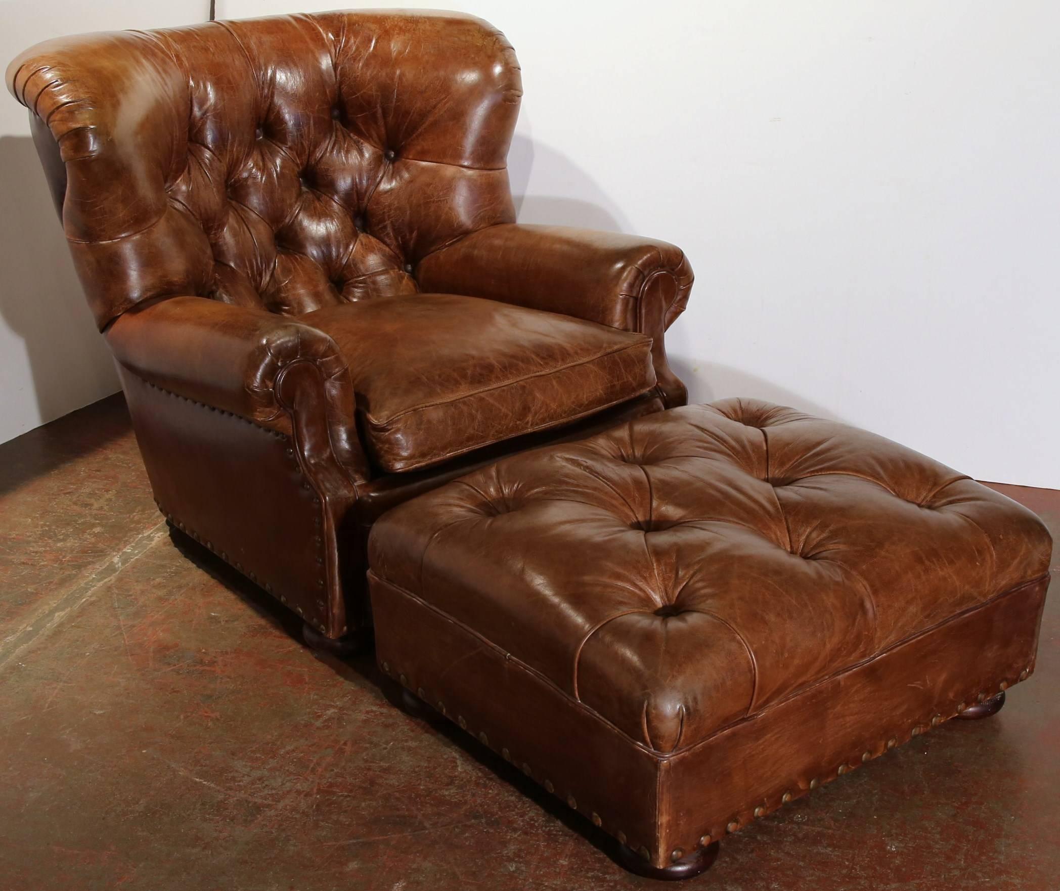 This exquisite brown leather armchair is a Ralph Lauren classic from 1970. The masculine armchair features a matching ottoman and would fit well in any living room. Both have a beautiful patina, nailhead detail and are in great condition.