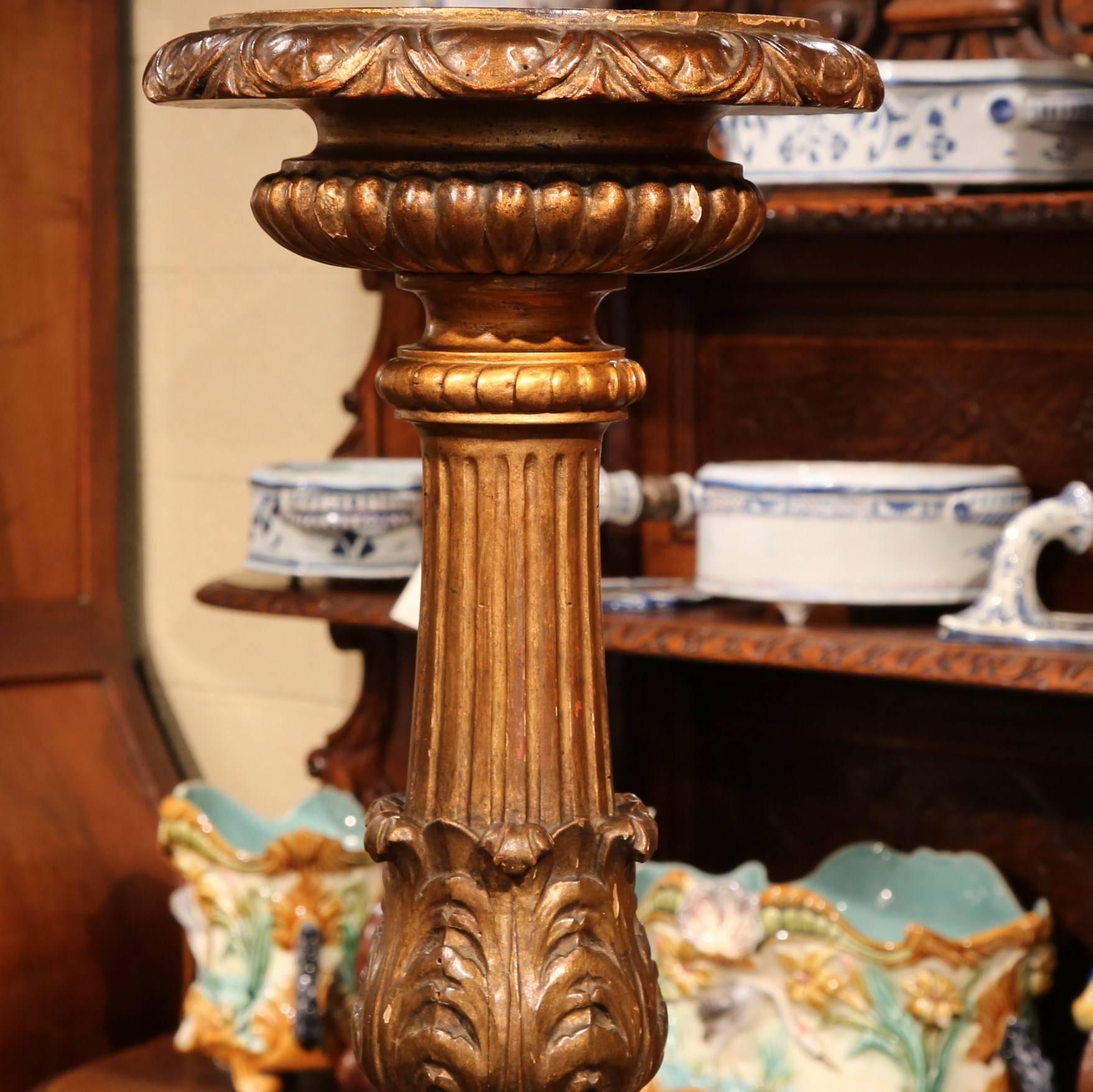 This elegant, large gilt candlestick was carved from wood in Italy, circa 1850. The candlestick has beautiful carvings all along the stem, a large diameter plate at the top, and three paw feet at the base. The candleholder is in excellent condition