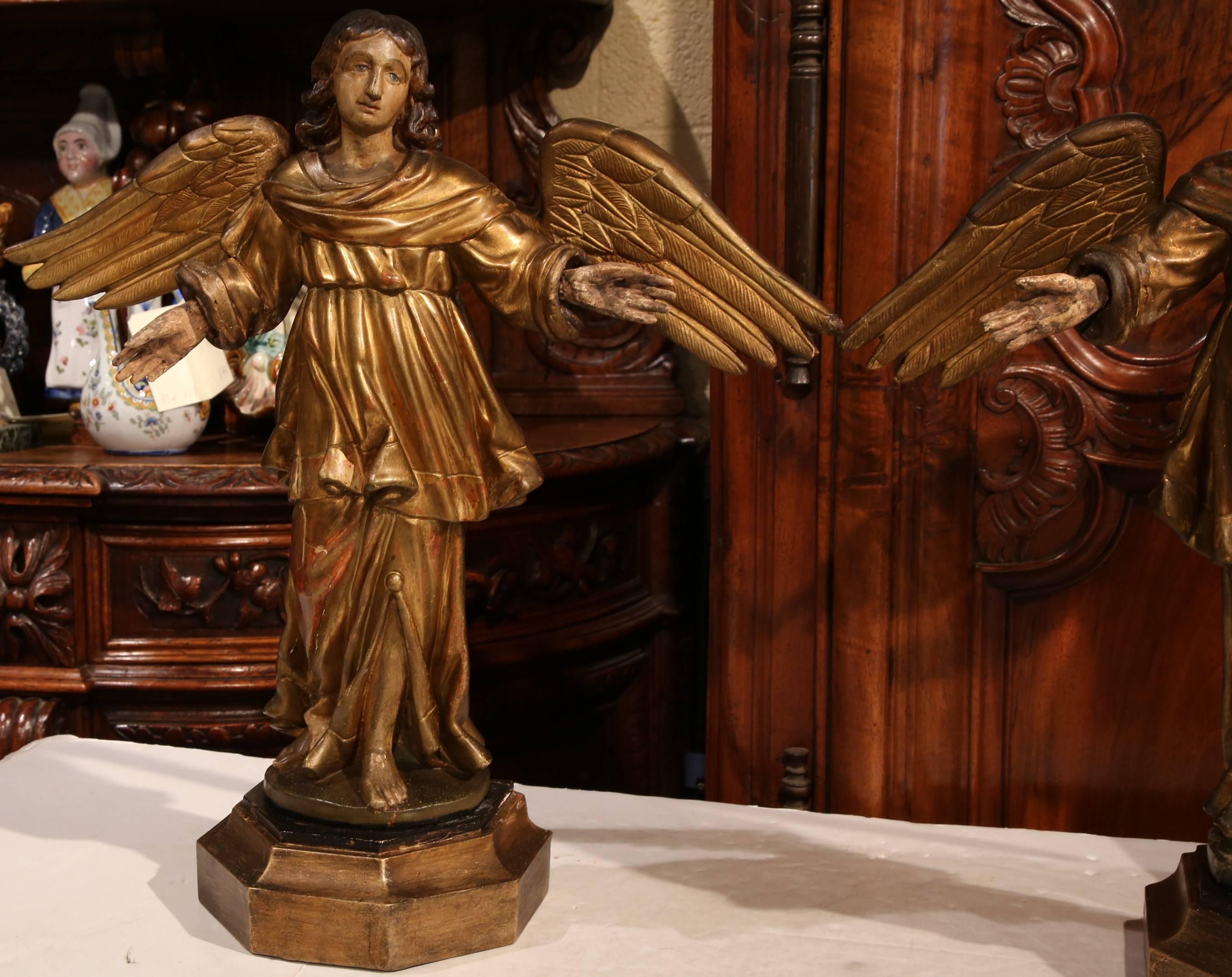 Decorate a mantel with this beautiful pair of antique statues from France. Carved circa 1870, the angels stand in adoration, and are embellished with their original wings, very detailed carvings on their clothes, a gold leaf finish and some
