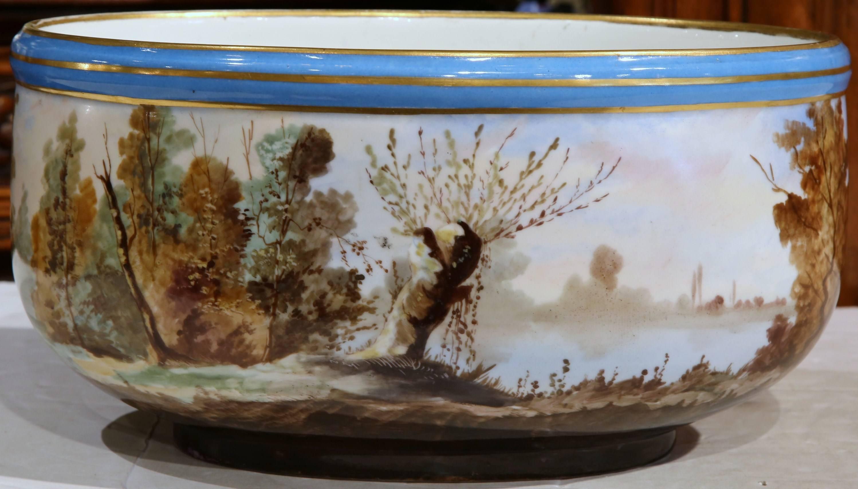 Decorate a shelf or tabletop with this large, hand-painted jardinière from Paris, France, circa 1860; this antique oval planter depicts a colorful harvest scene with cows and farmers picking hay. The porcelain piece is very detailed with vivid